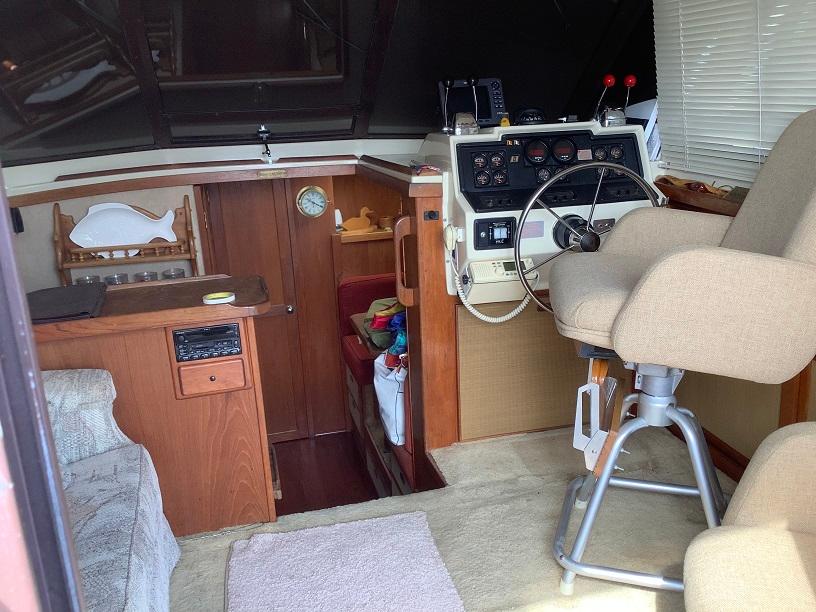 Interior of a 1982 Trojan F32 boat with helm, seating, and wooden cabinetry.
