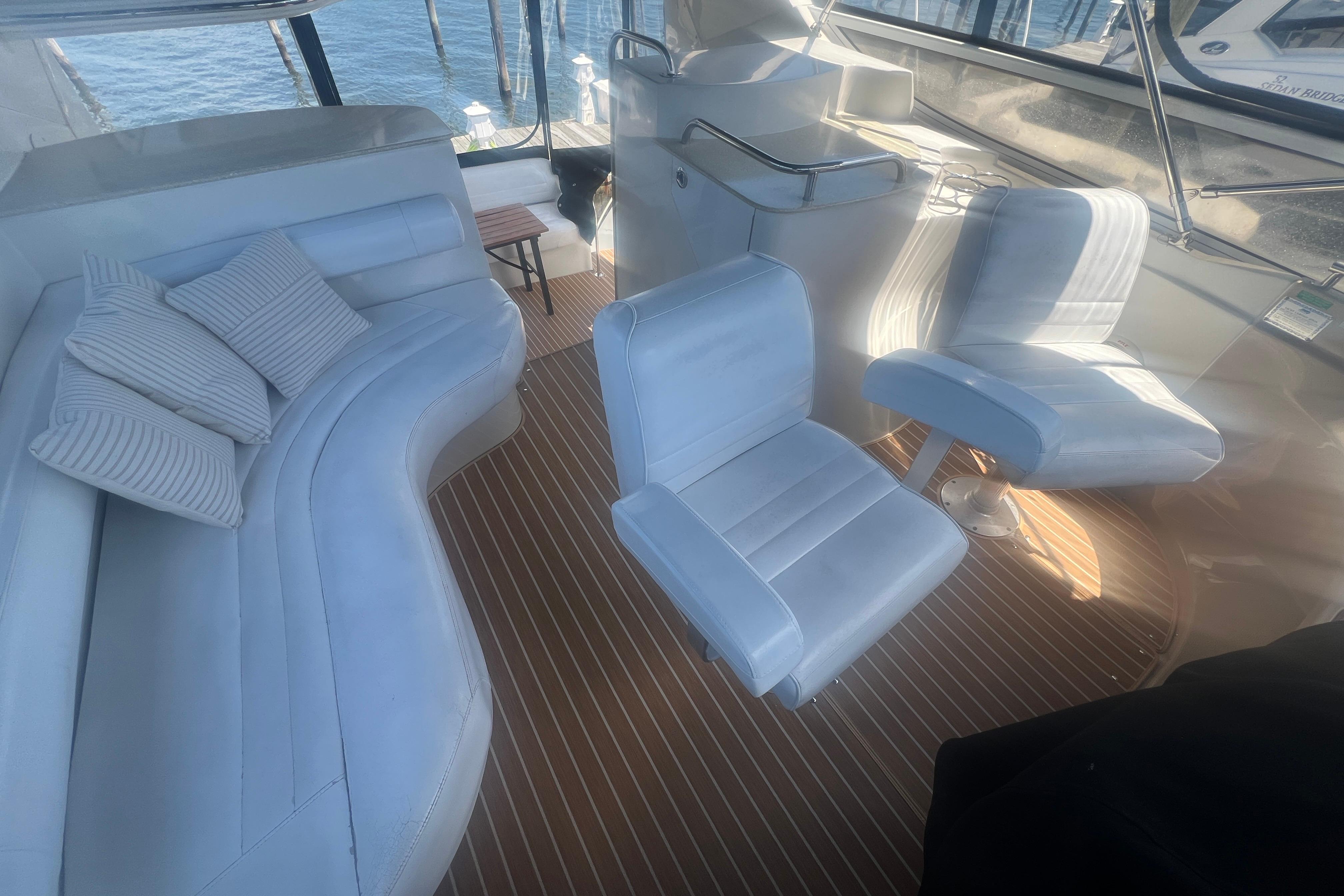 Luxurious interior of a 2006 Carver 43 Motor Yacht with white seating and striped flooring.