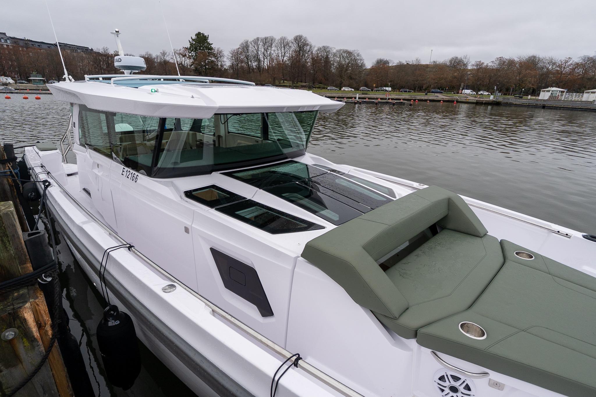 2027 Axopar 38 Cross Cabin boat docked by a calm river.