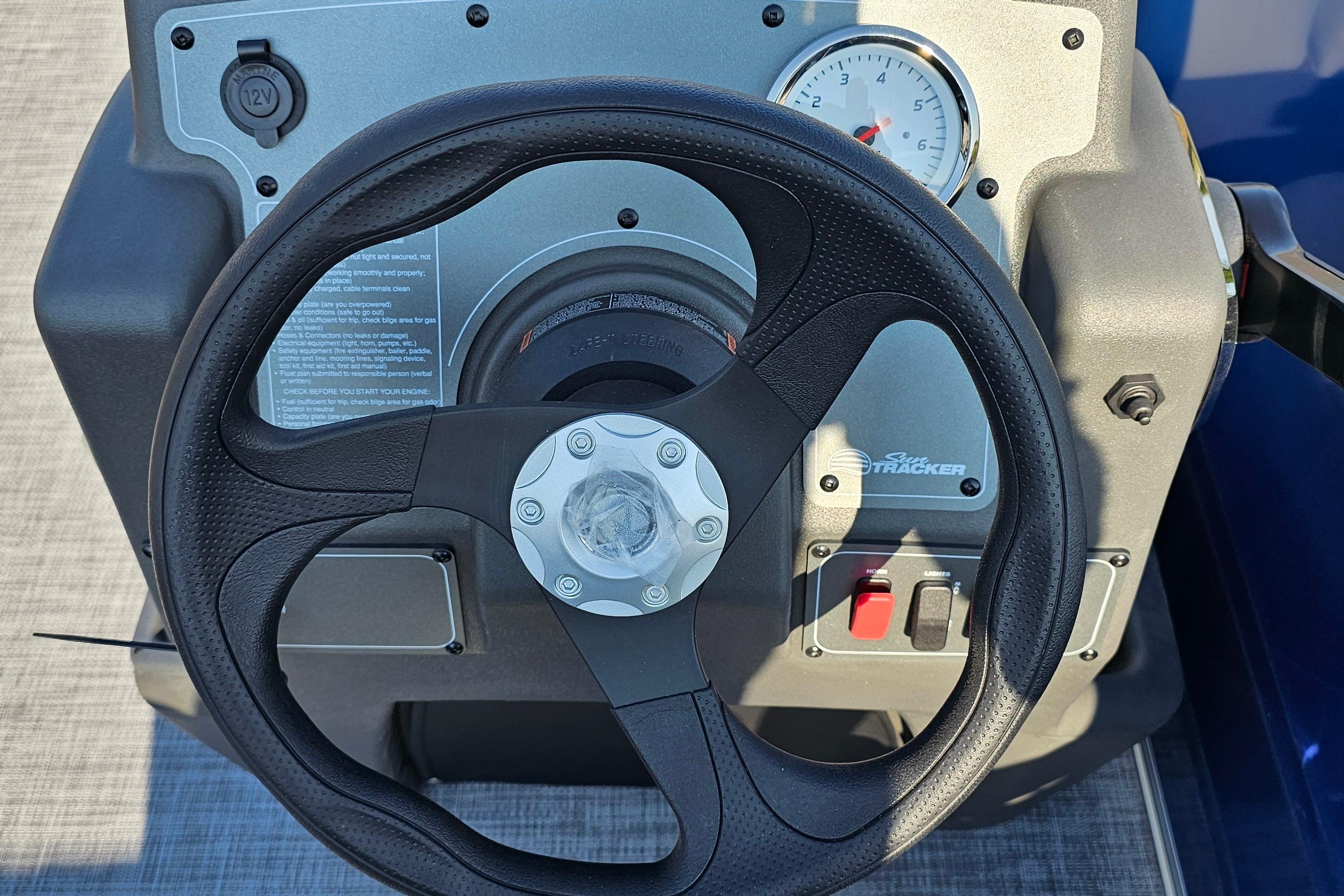 Steering console of 2026 Sun Tracker Party Barge 16 DLX with gauge and controls.