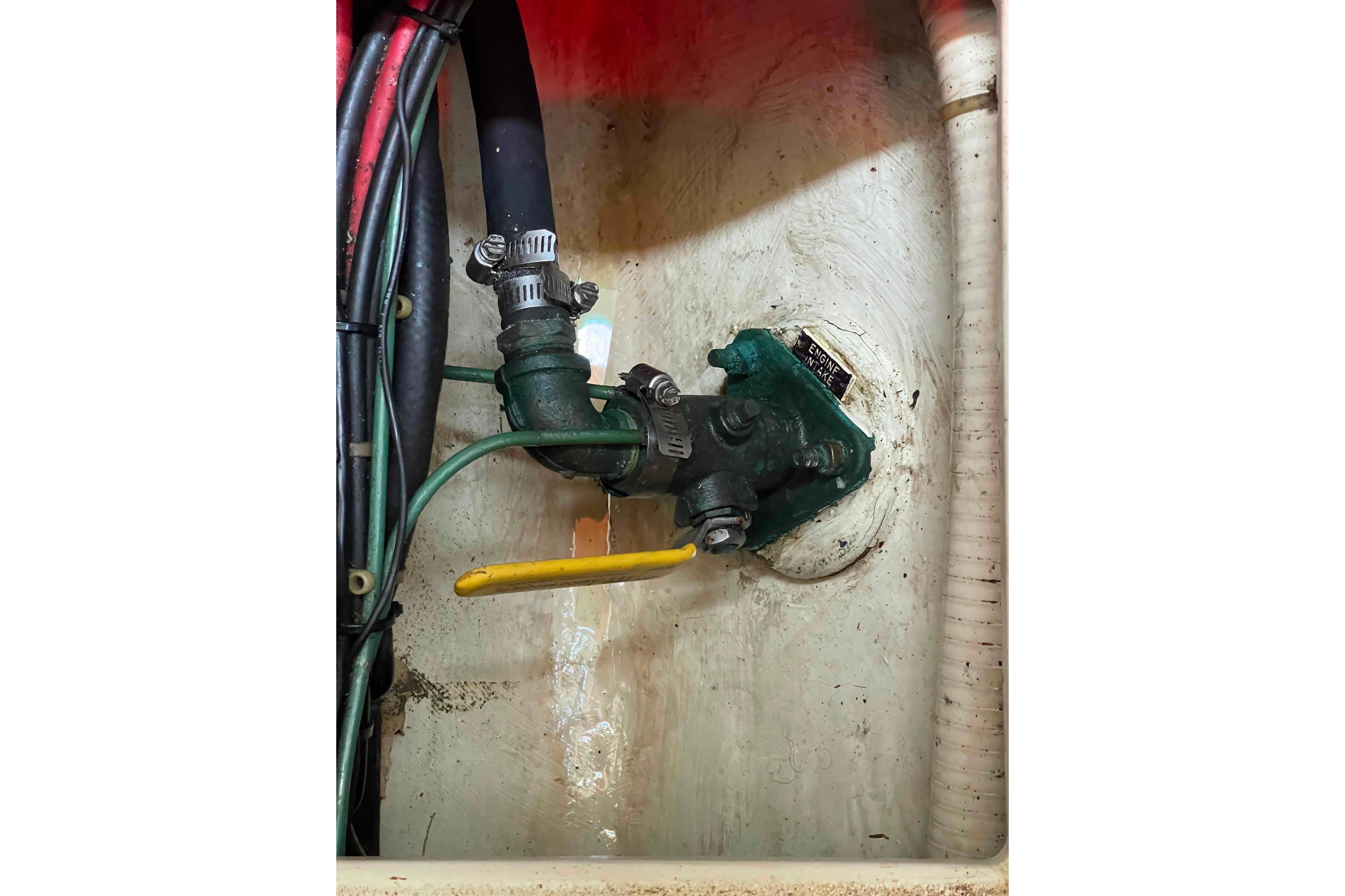 Engine compartment of a 1987 Pacific Seacraft 34, showing hoses and valve connections.