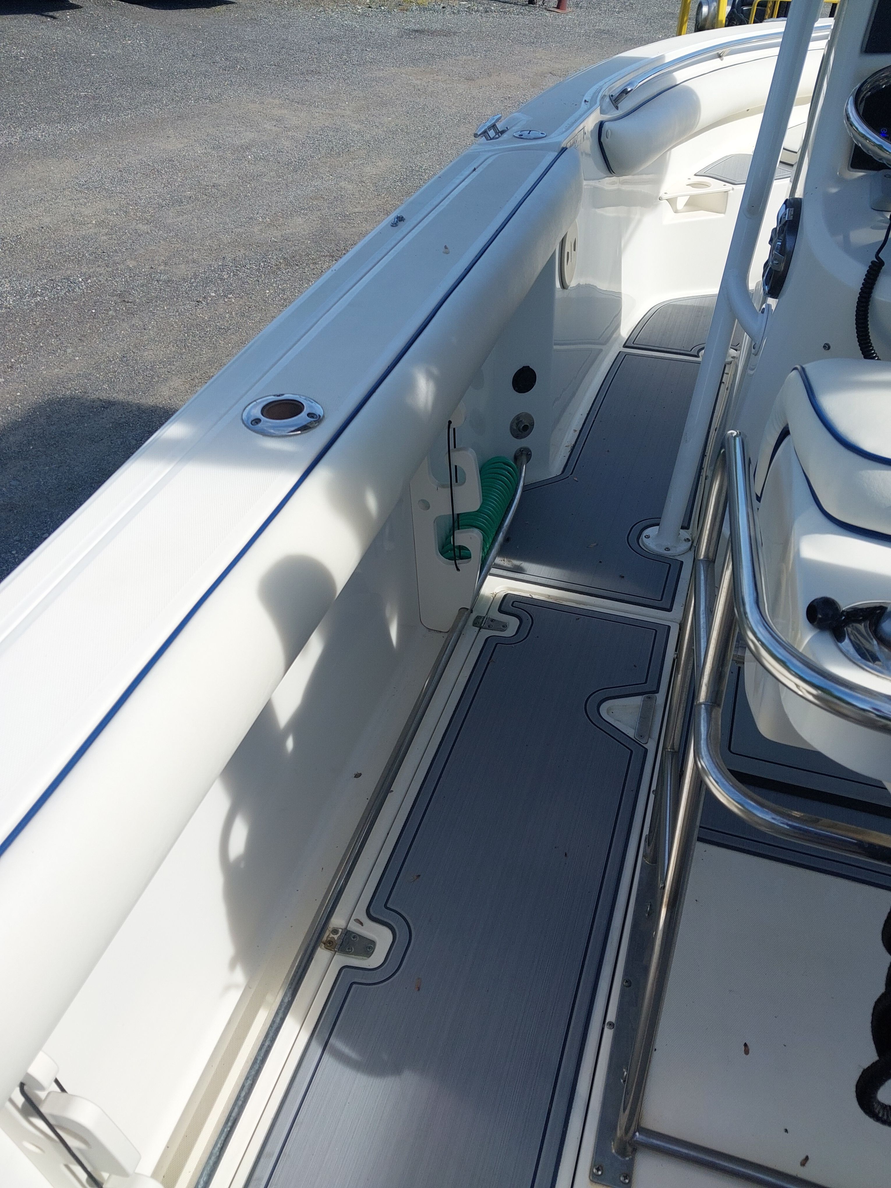 The image shows the deck of a 2005 Boston Whaler 240 Outrage with white seating and gray flooring.