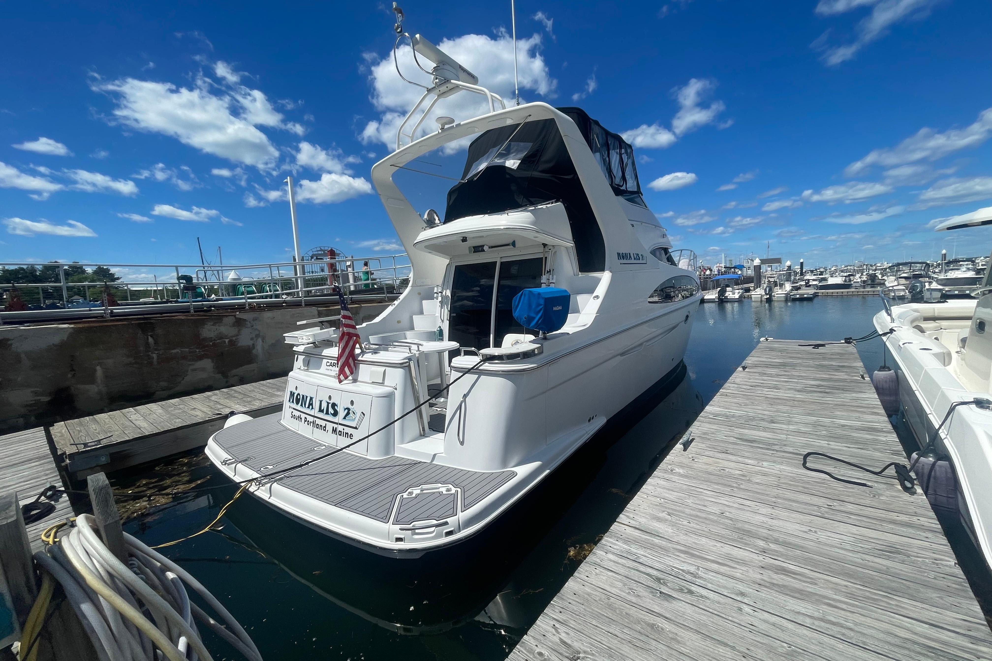 2002 Carver 410 Sport Sedan docked at marina under clear blue sky.