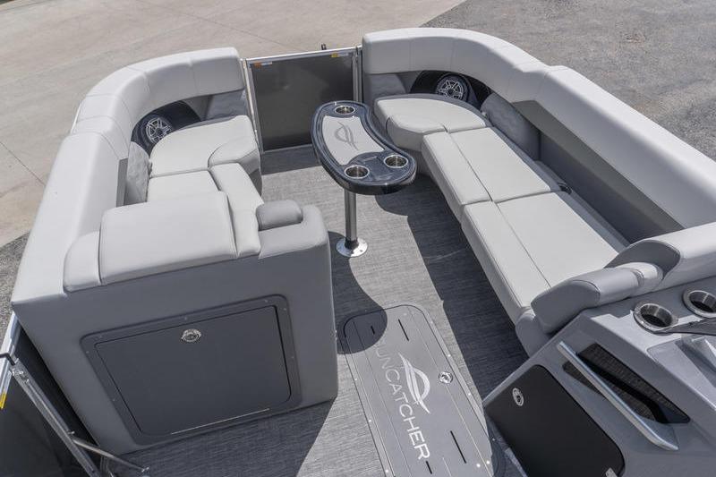 Luxurious interior of 2026 SunCatcher Elite 326 SL pontoon boat with plush seating and table.