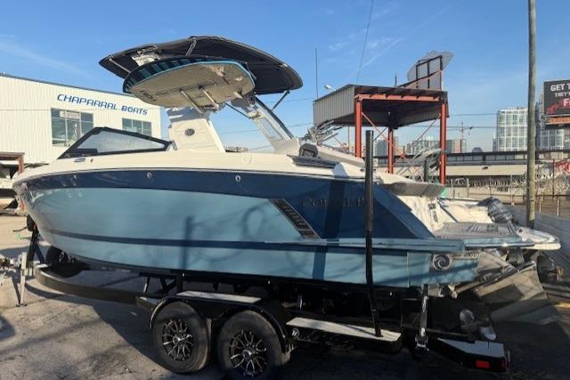 2023 Cobalt R6 Surf boat on trailer, blue and white, parked outdoors.