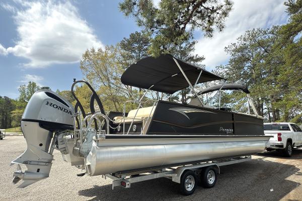 2022 Premier 250 Solaris pontoon boat on trailer with Honda outboard motor, parked outdoors.