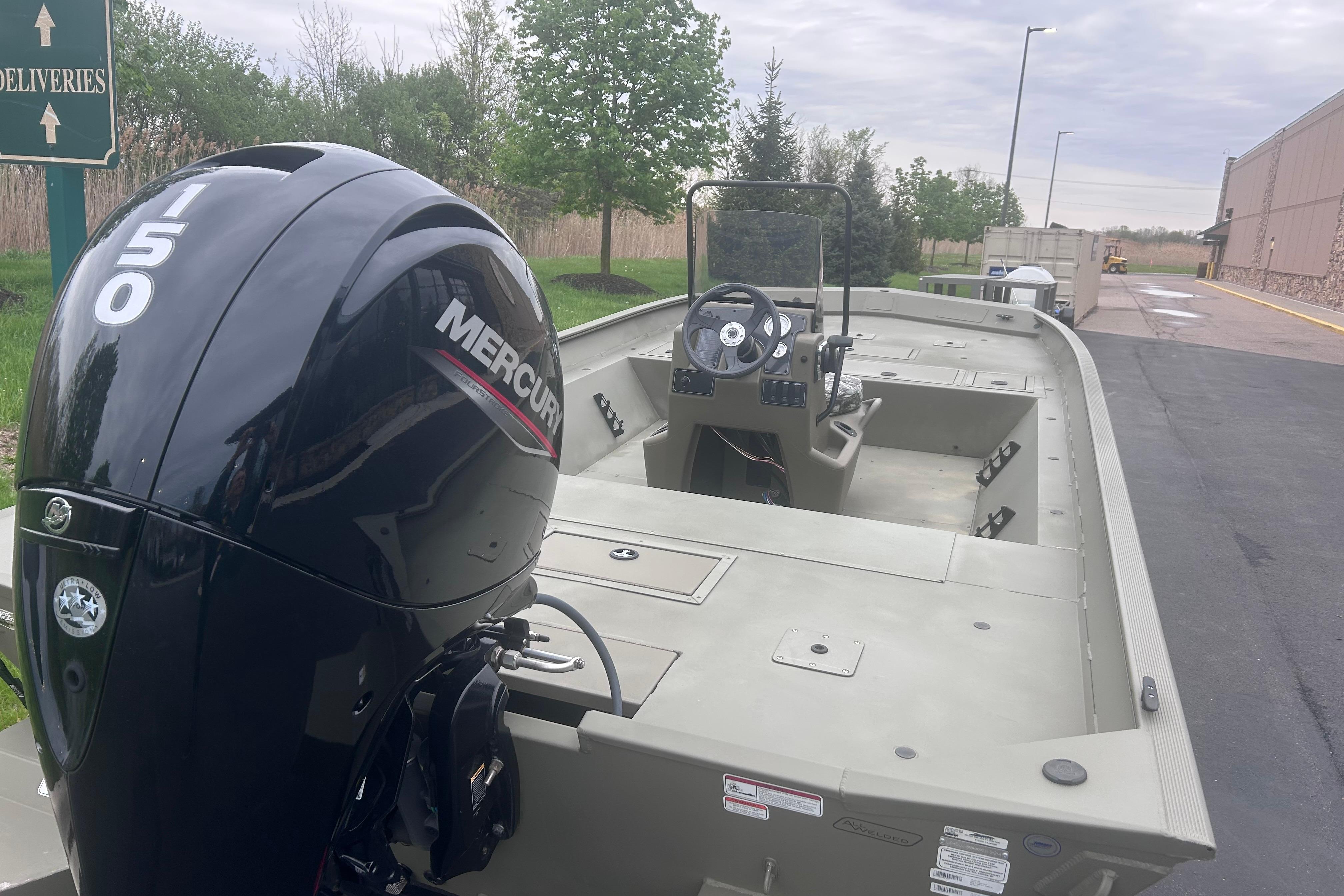 2024 Tracker Grizzly 2072 CC boat with Mercury 150 engine, parked outdoors.