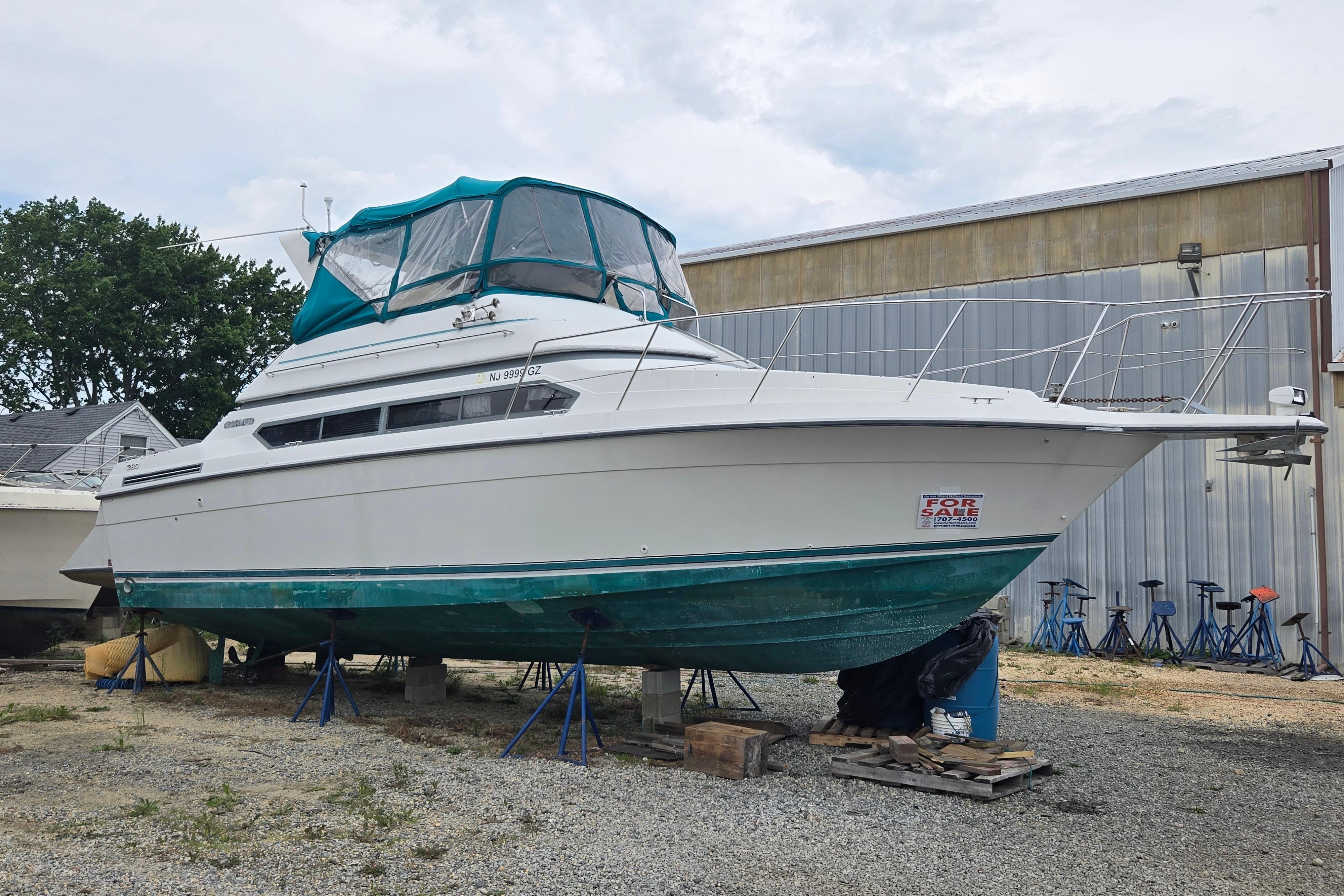 1994 Carver 380 Santego boat on stands, for sale, with teal canopy.