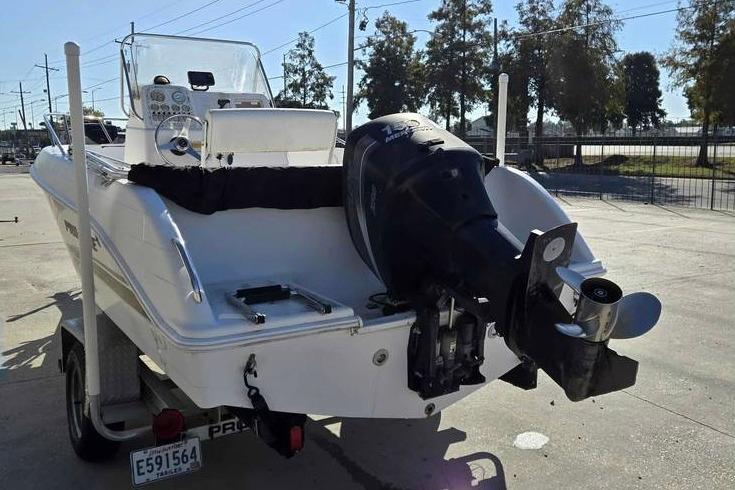 2001 Pro-Line 19 Sport boat with outboard motor on trailer, parked outdoors.