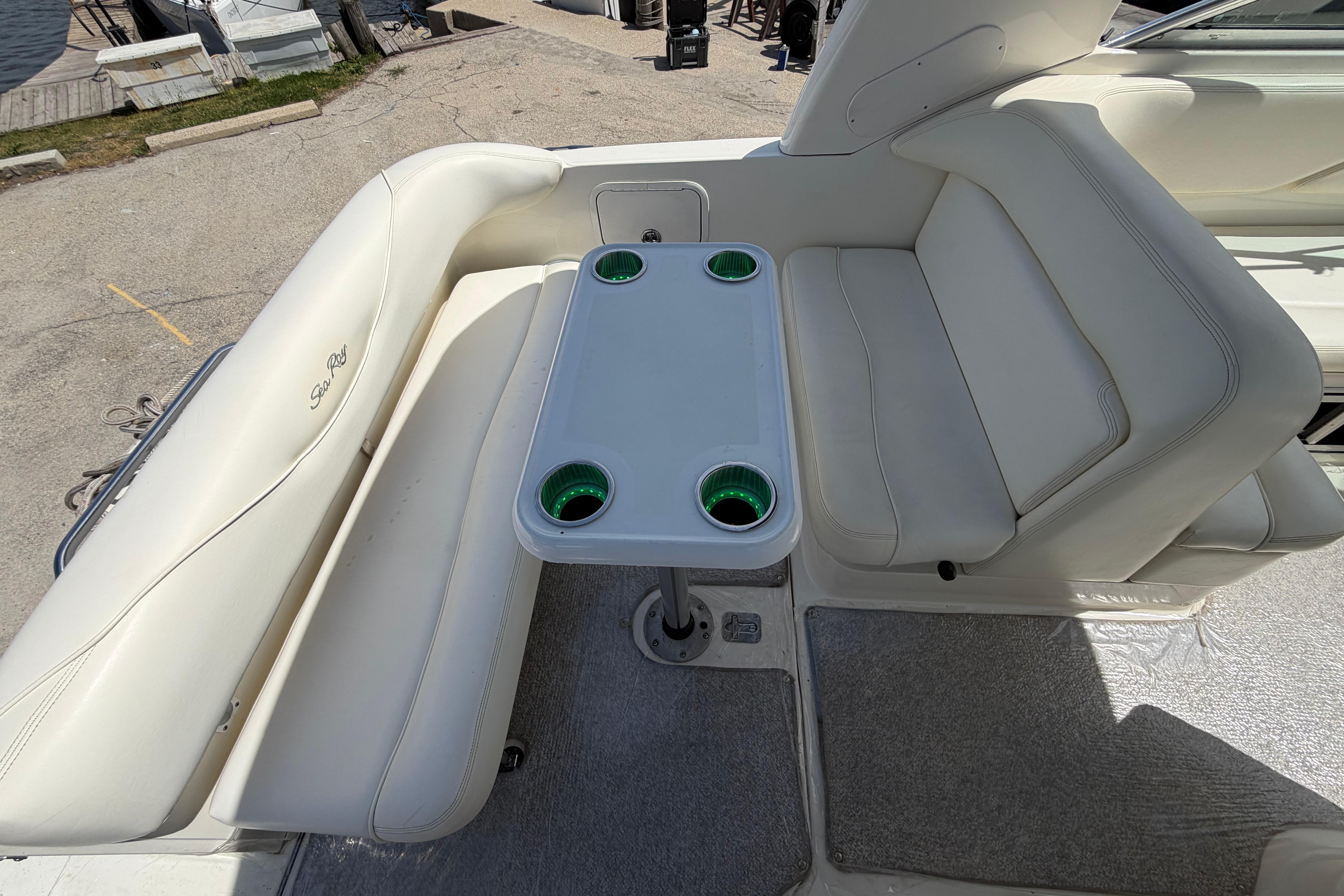 2004 Sea Ray Sundancer 260 boat interior with white seating and table, docked at marina.