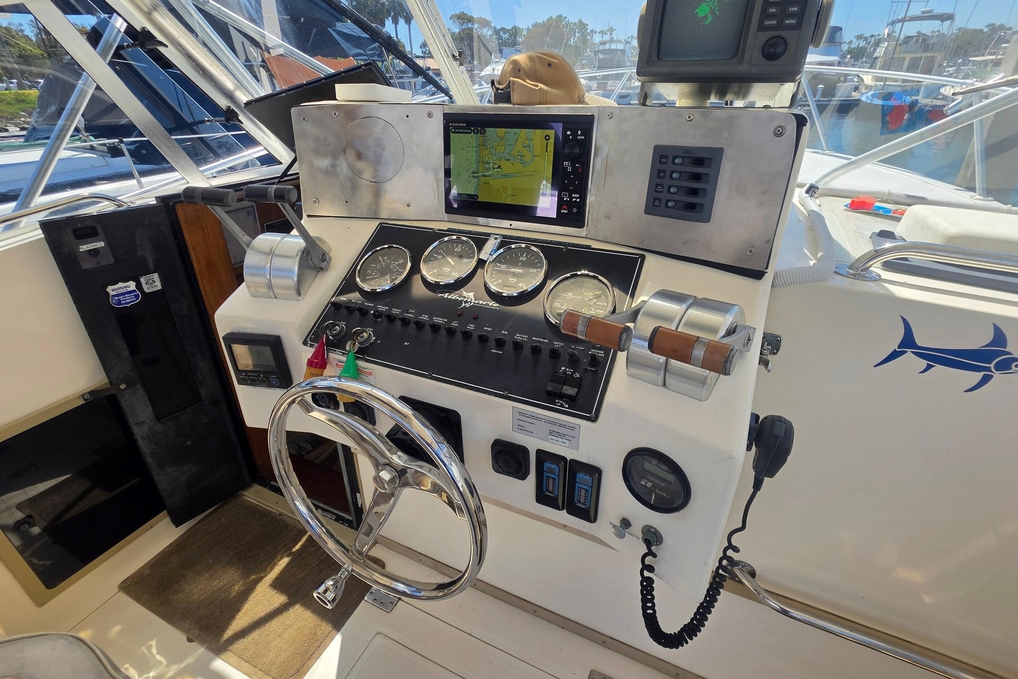 1999 Albemarle 305 Express Fisherman helm with navigation instruments and steering wheel.