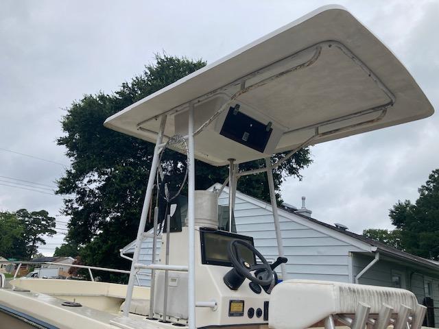 1995 KenCraft Challenger 190 boat with T-top and steering console, parked outdoors.
