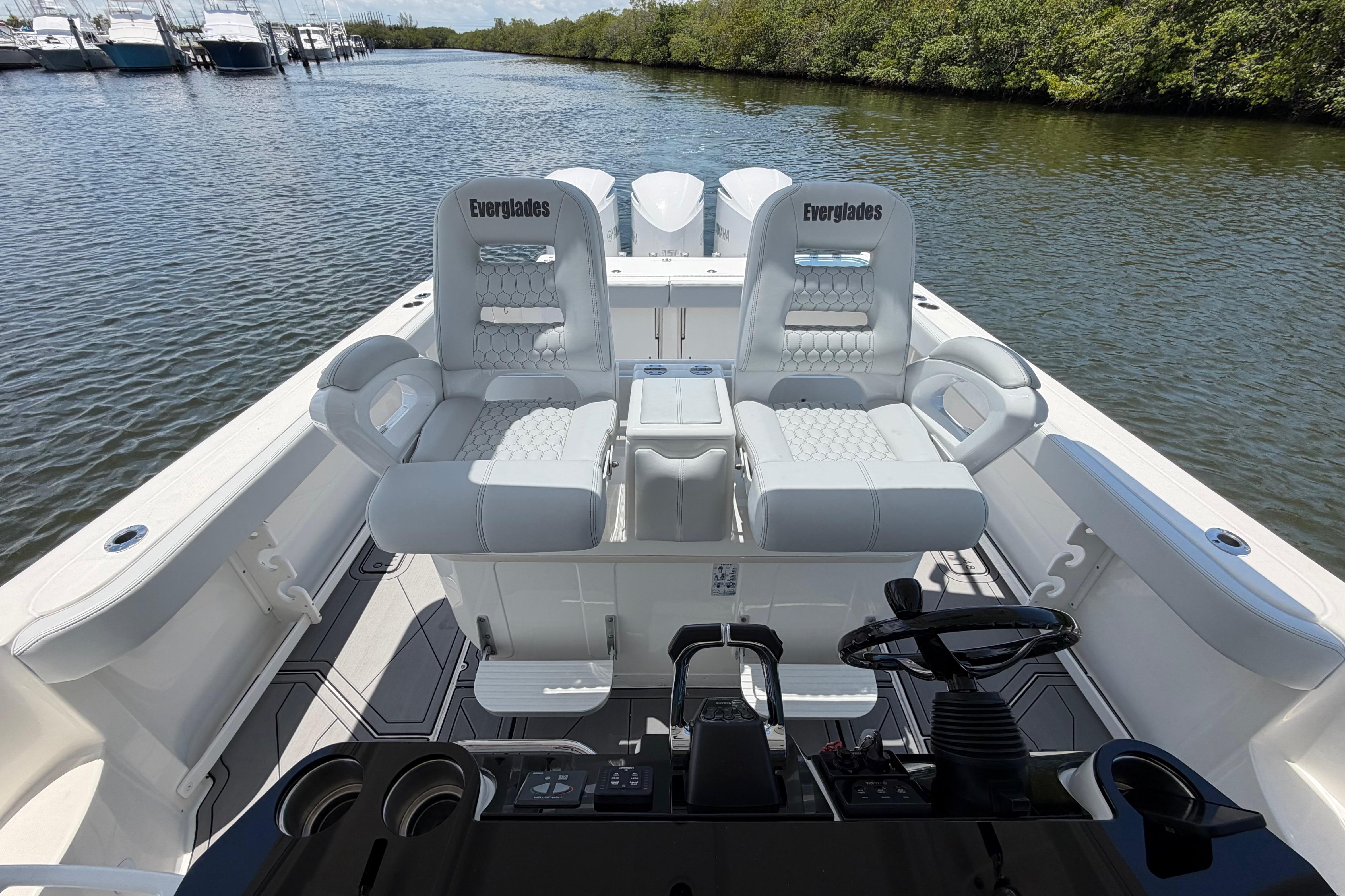 2009 Everglades 350LX boat interior with dual captain's chairs on a calm waterway.