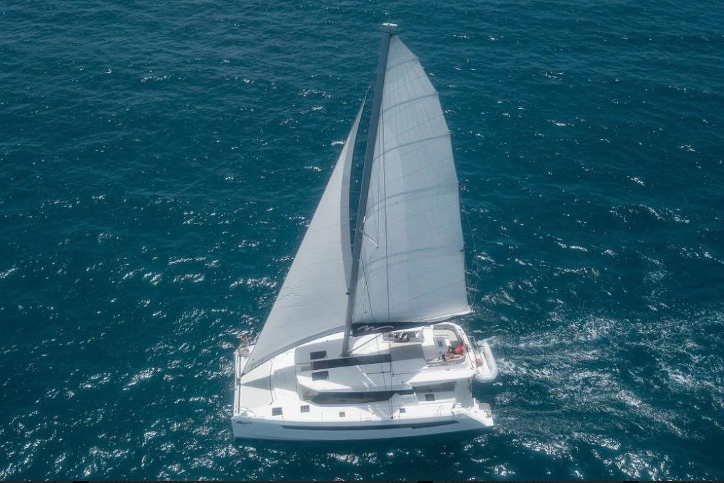 Aerial view of 2021 Leopard 50 sailing catamaran on open ocean.