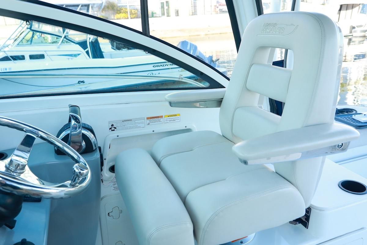 Captain's seat and helm of 2016 Boston Whaler 285 Conquest boat, featuring sleek design.