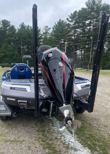 2025 Ranger Z520R boat with powerful outboard motor, parked on gravel, surrounded by trees.