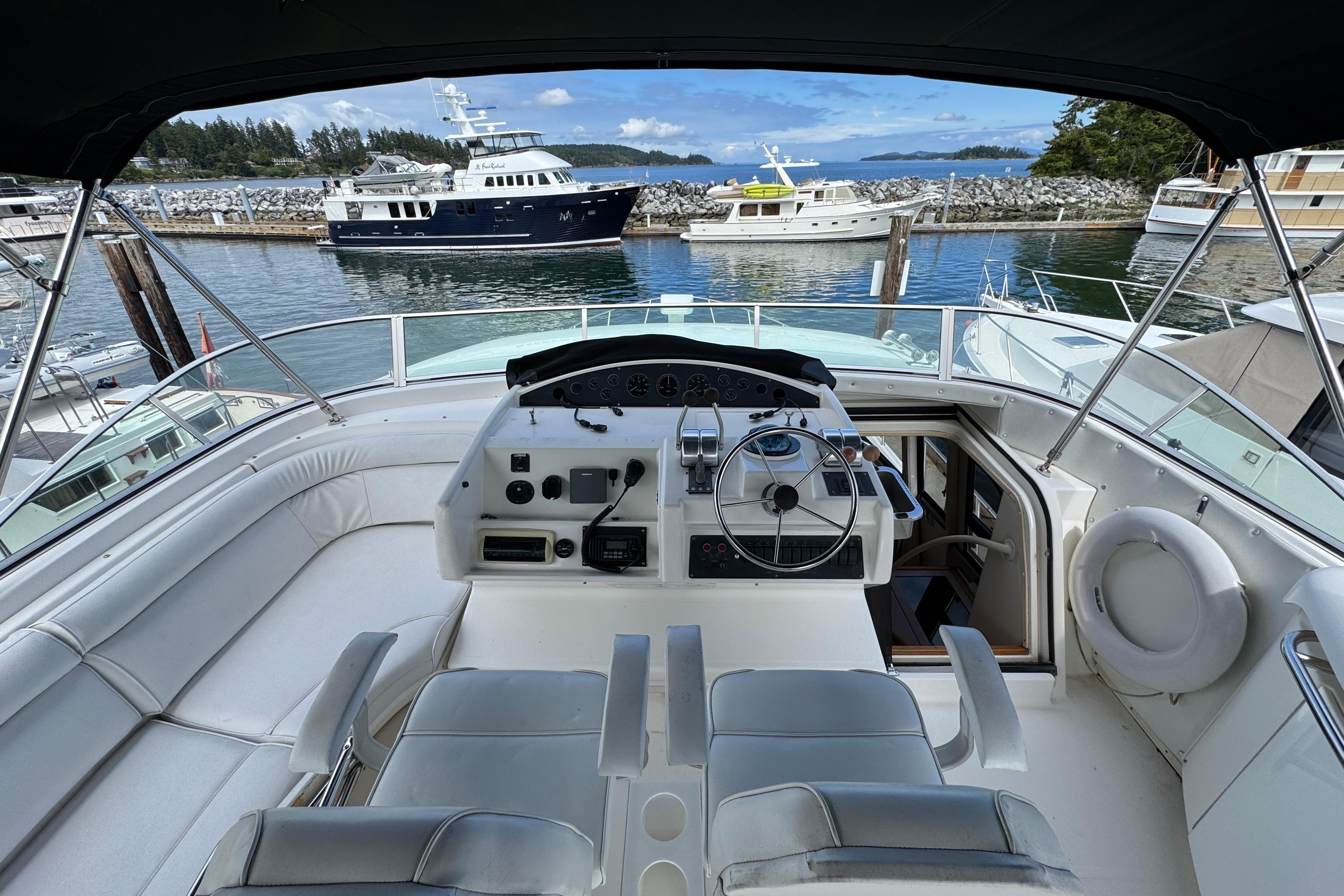 1998 Bayliner 5788 Pilot House Motoryacht helm with marina view in background.
