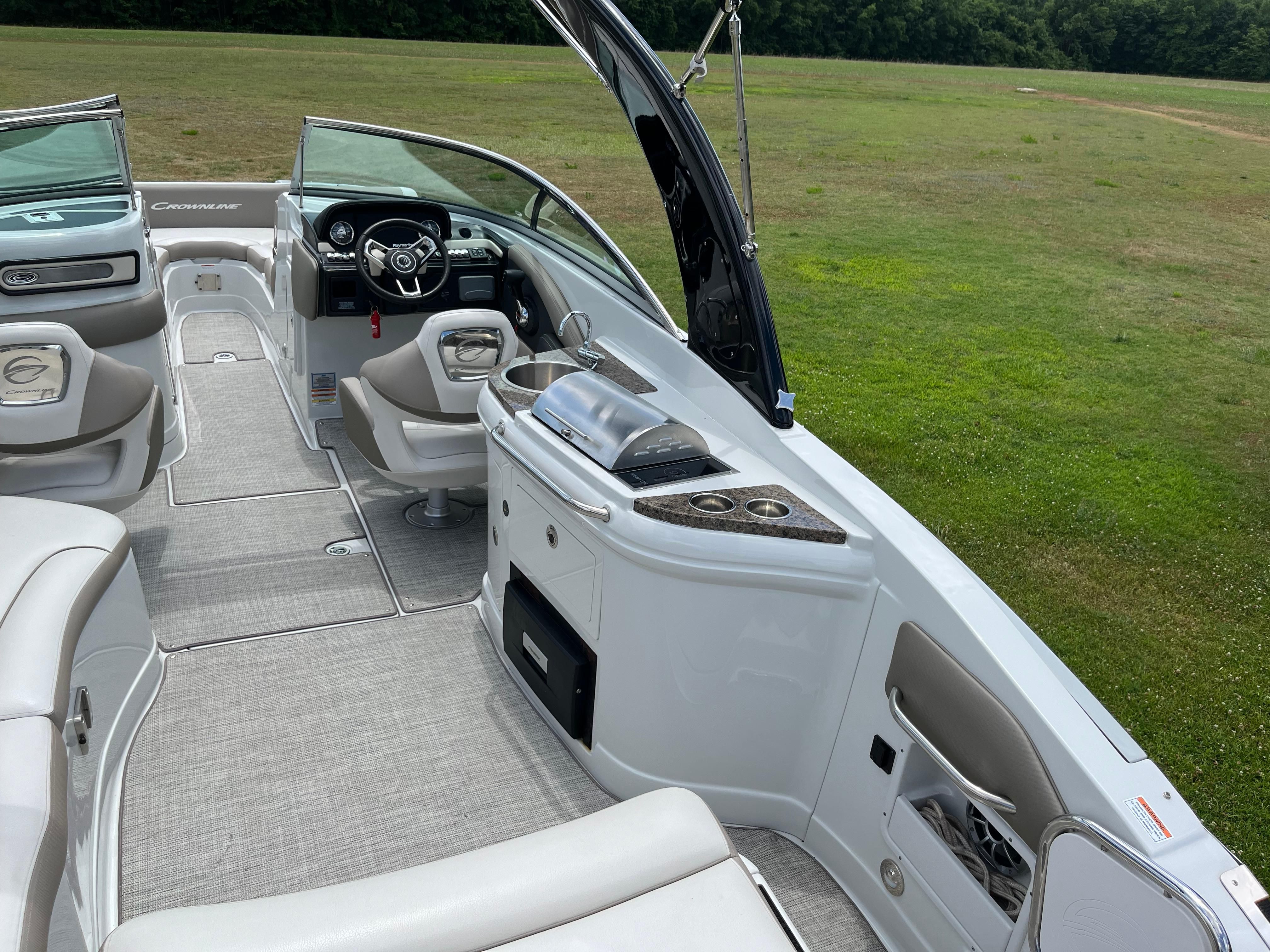 The image shows the cockpit of a 2019 Crownline E 285 boat with gray carpeting.