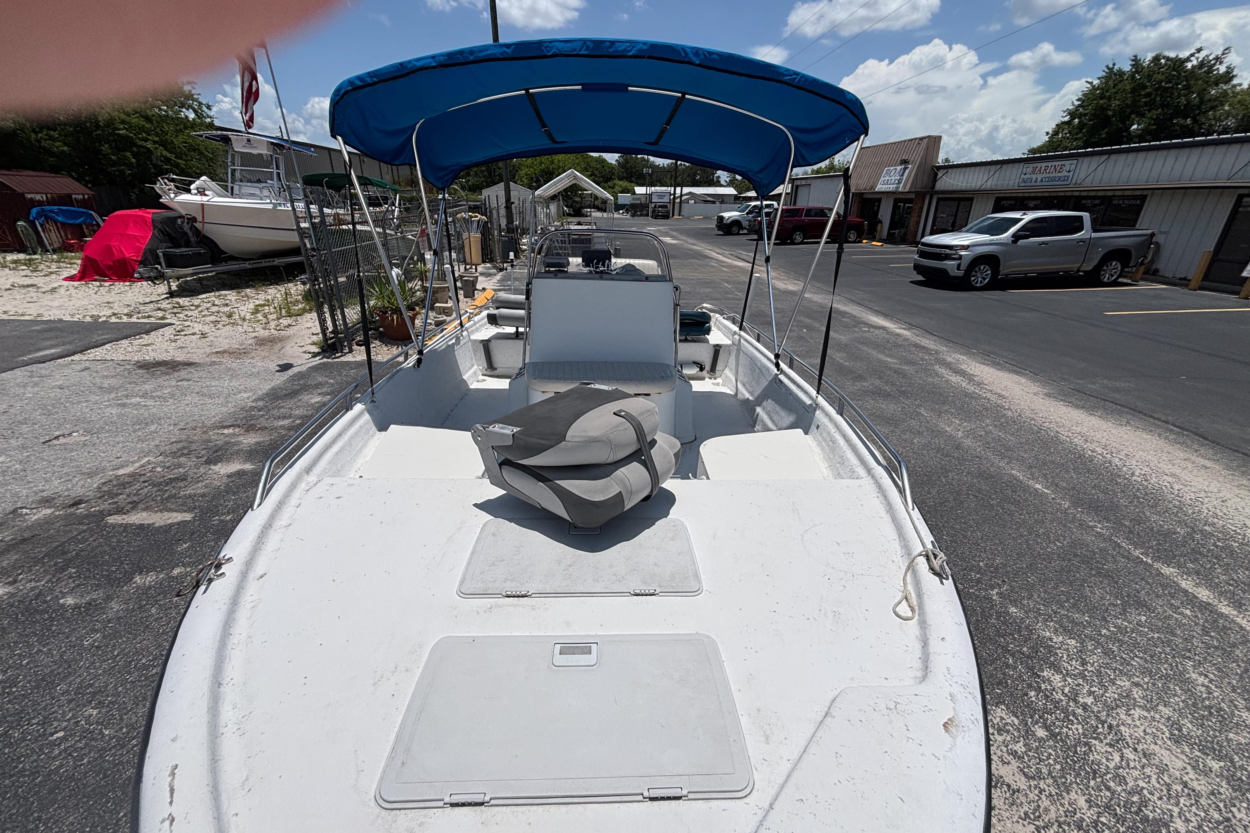 2000 VIP 1880 BAY STEALTH boat with blue canopy, parked outdoors on a sunny day.