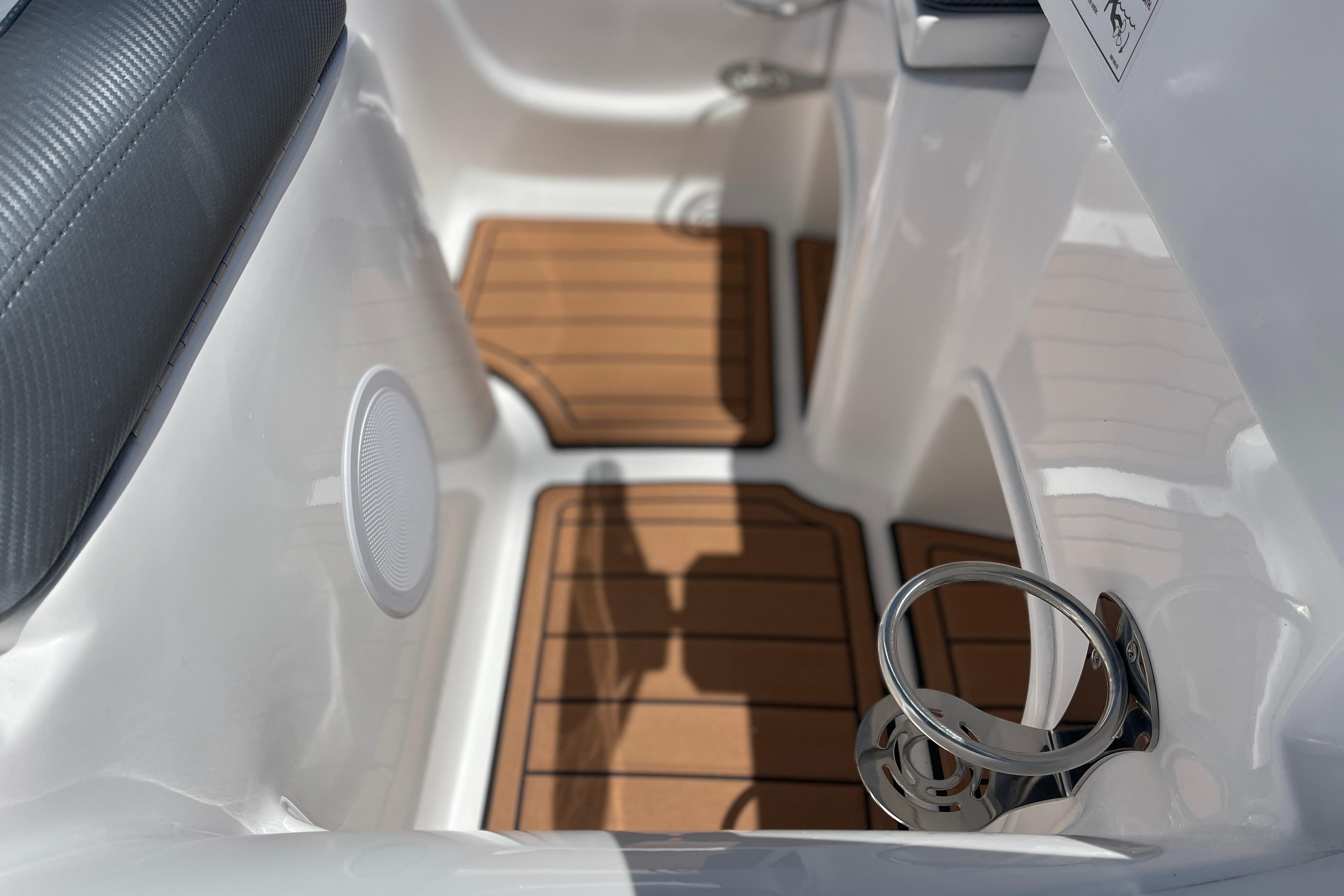 Interior of 2025 Caribe DL11 boat with wood flooring and cup holder.
