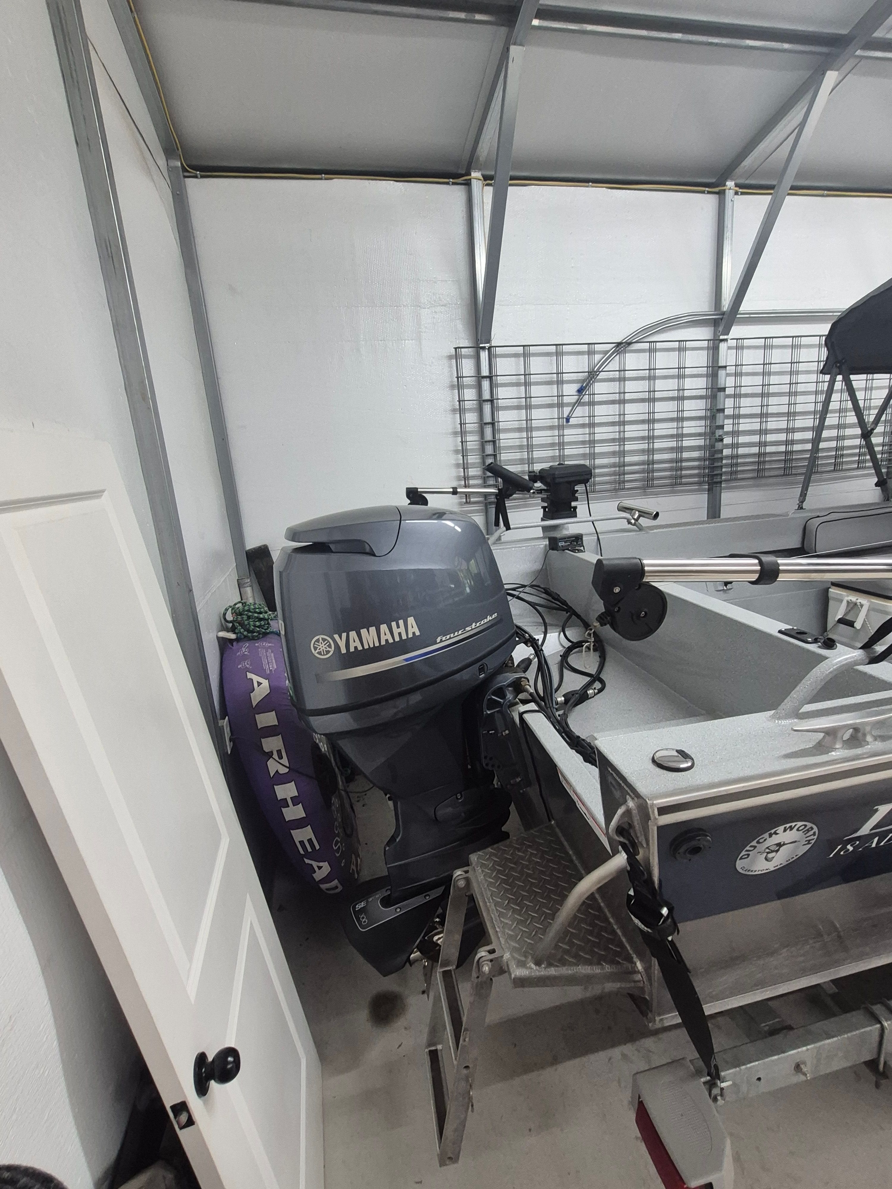 A 2016 Duckworth 18 Advantage boat with a Yamaha outboard motor in a garage.