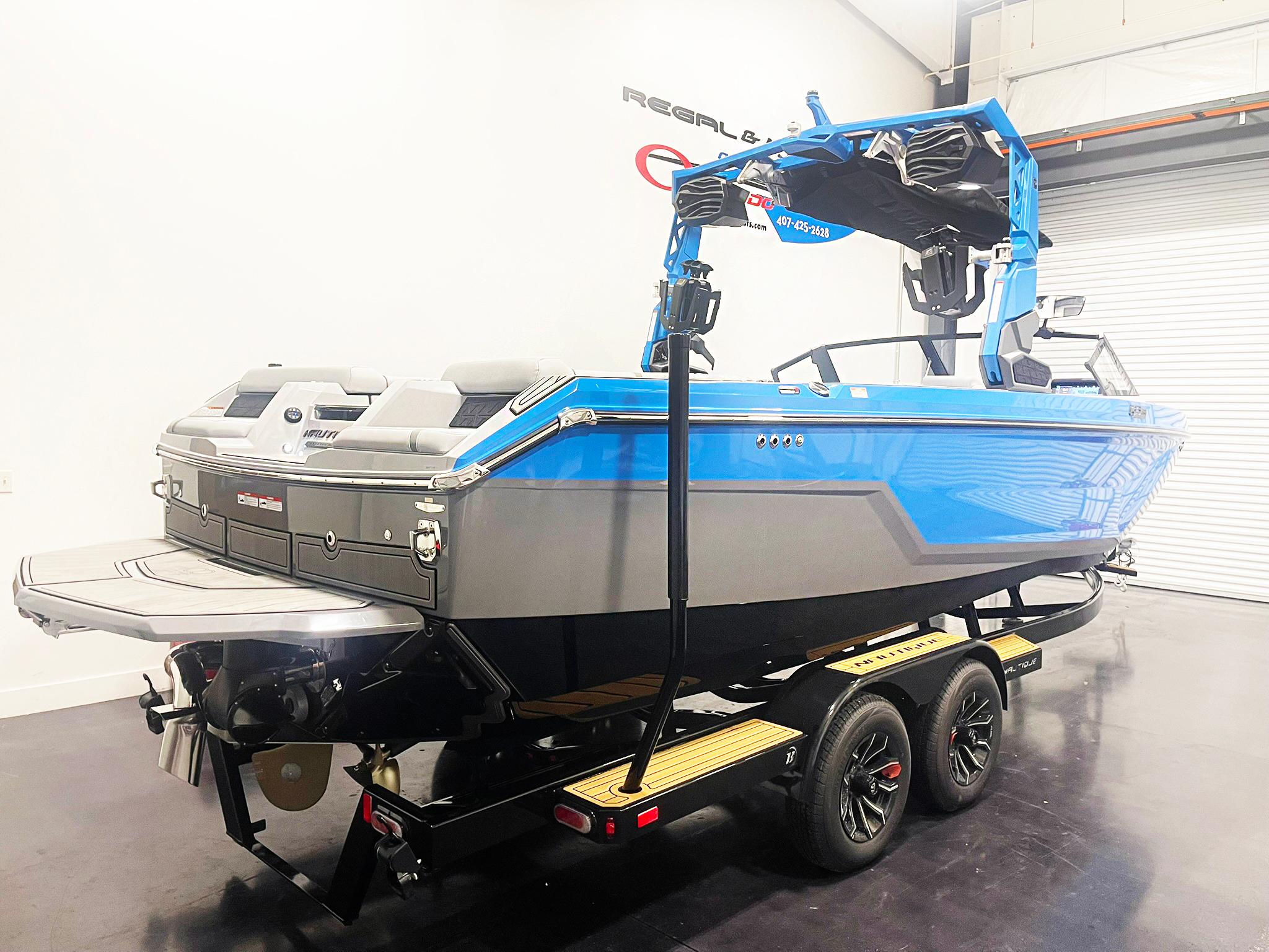 2025 Nautique Super Air Nautique GS24 boat in showroom, blue and gray design on trailer.