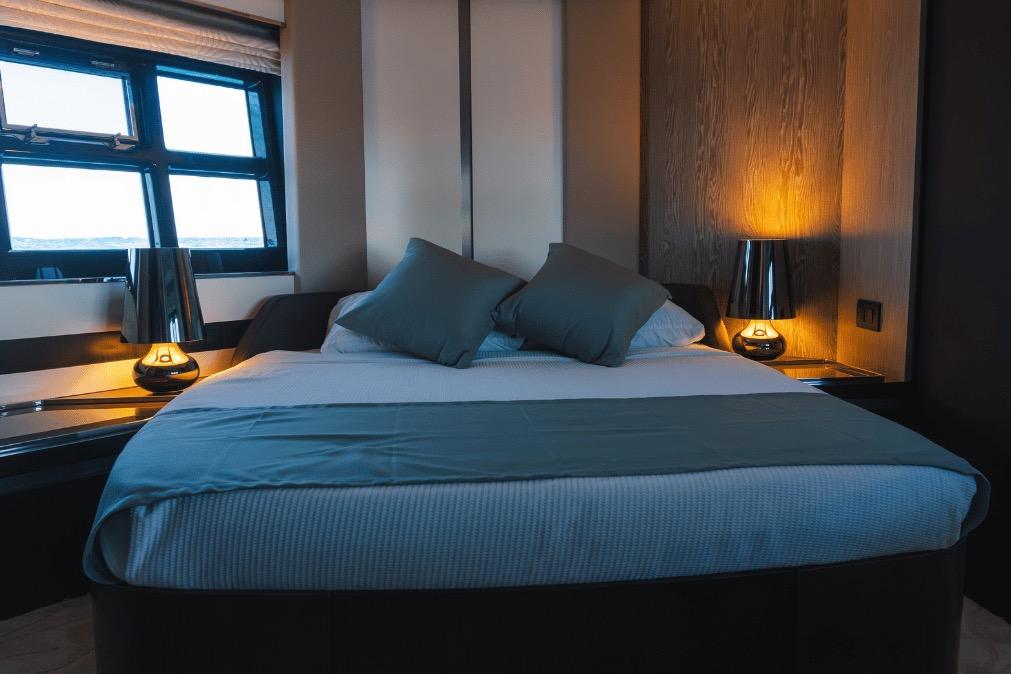 Luxurious bedroom interior on a 2020 Azimut 60 yacht, featuring elegant lighting and modern design.