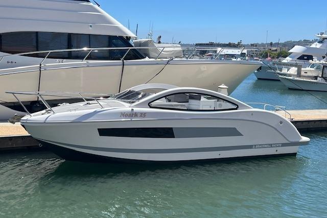 Modern 2024 Bracewell 25 boat docked in marina, sleek design and white exterior.