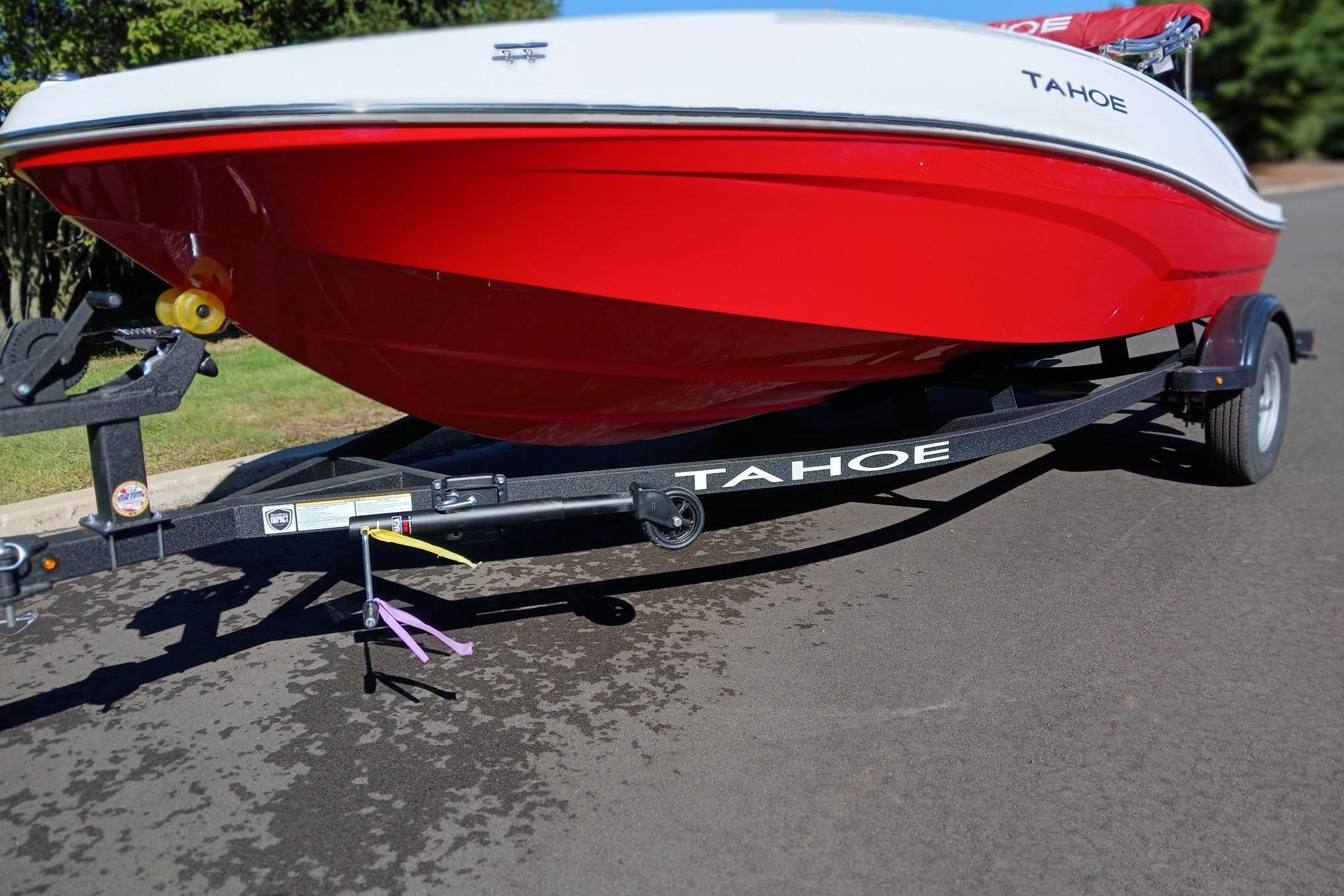 2026 Tahoe T16 boat on trailer, red and white design, parked on pavement.