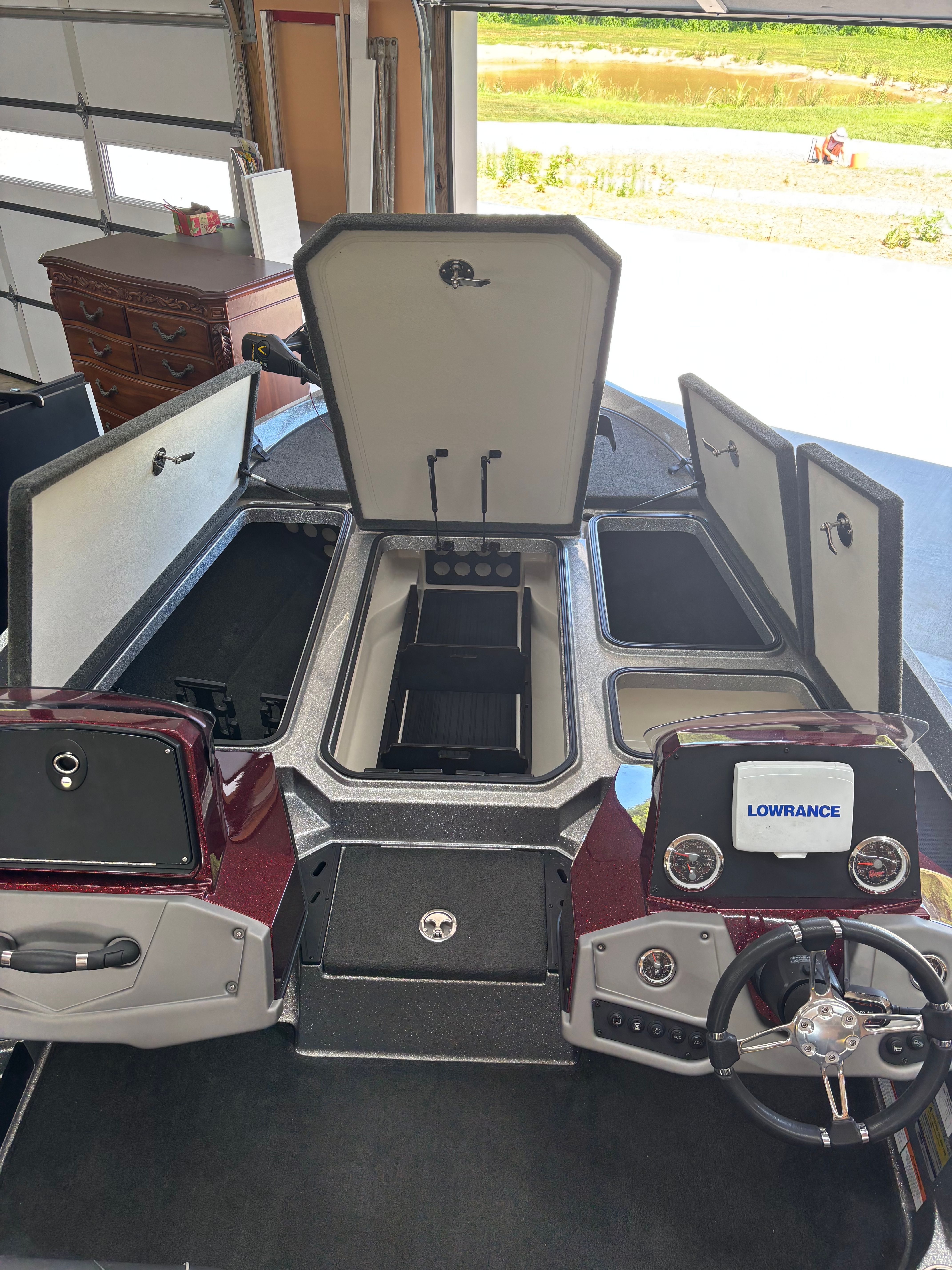A 2016 Ranger Z 185 boat in a garage with open storage compartments.