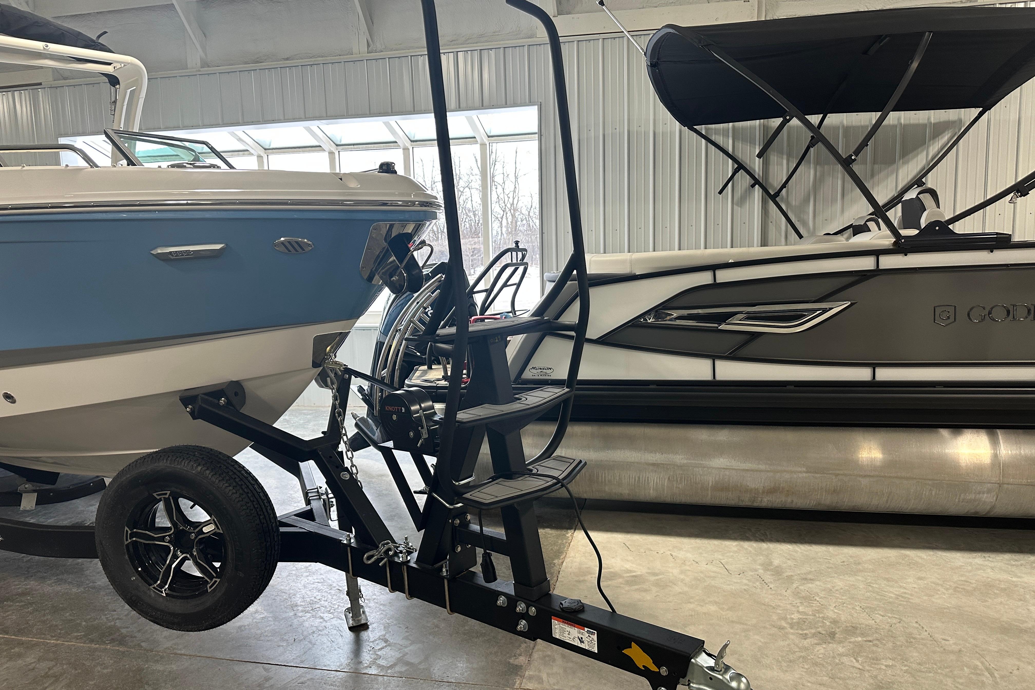 Chaparral SSX 6 2026 boat in a warehouse next to a pontoon boat.