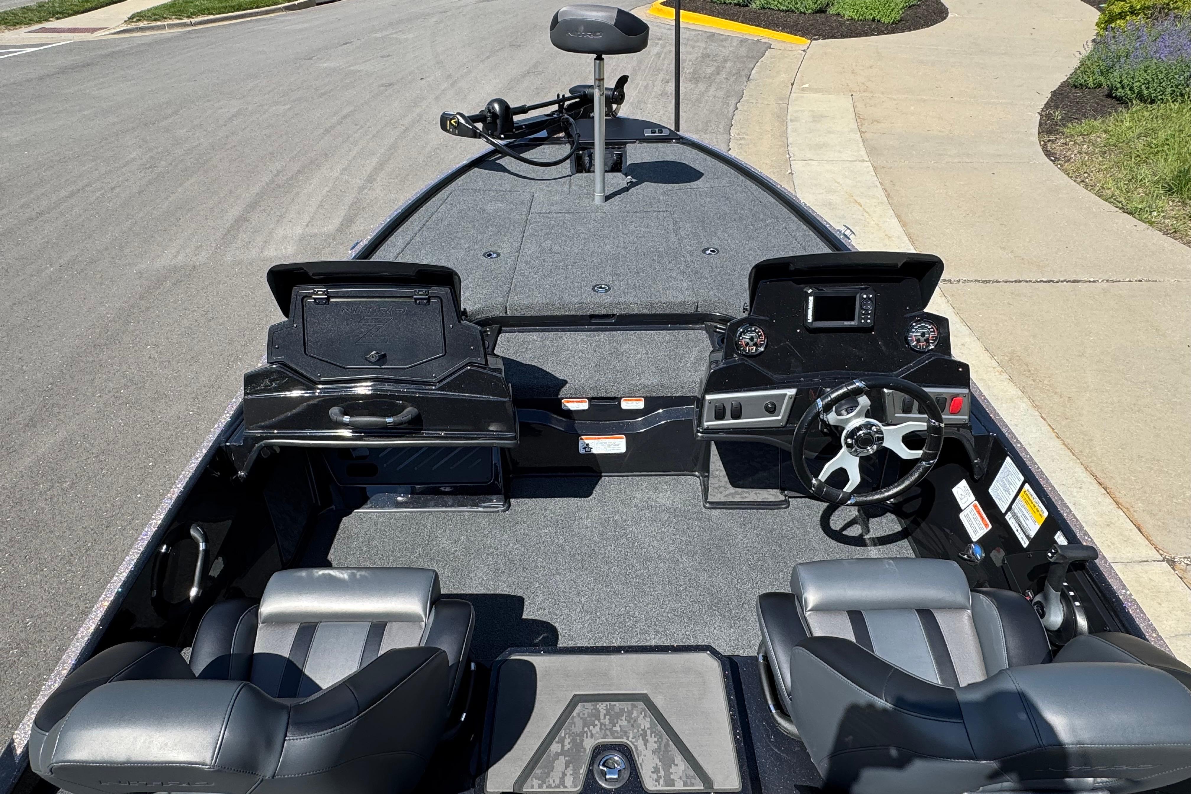 2026 Nitro Z19 XL boat interior with dual consoles and steering wheel, parked on a street.