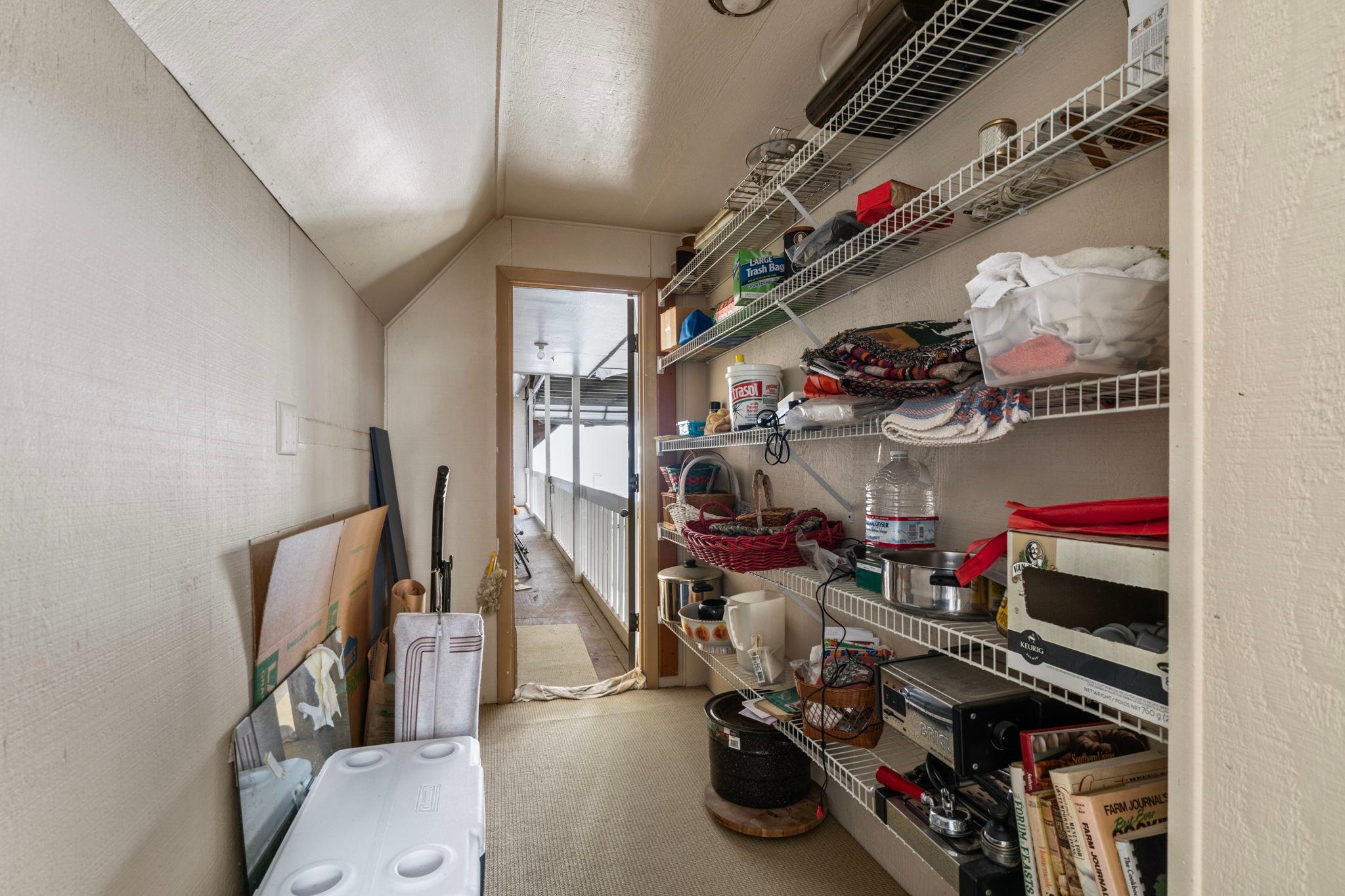 Storage room in a 1976 custom boathouse with shelves and various household items.