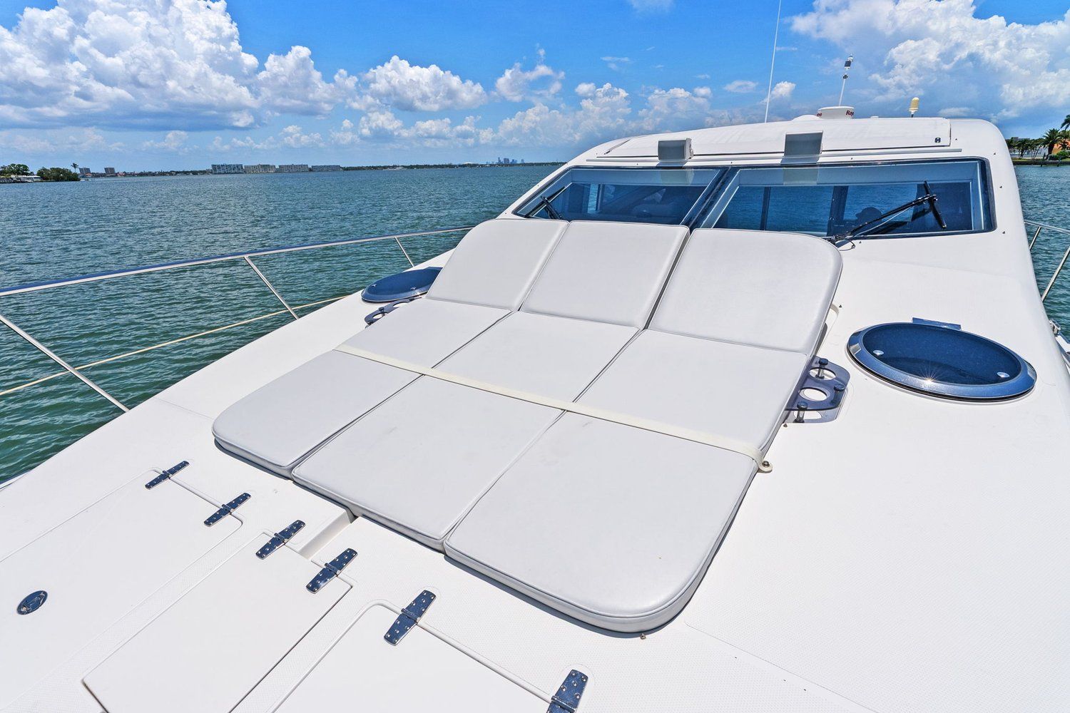 A luxurious catamaran with sun loungers on deck, surrounded by calm water and blue sky.