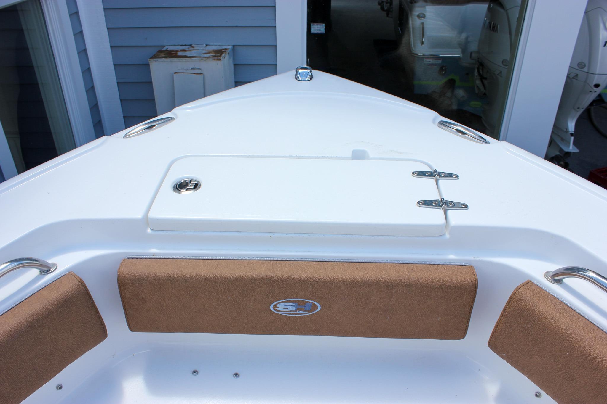 Bow view of 2027 Sea Hunt Ultra 234 boat with cushioned seating and storage hatch.