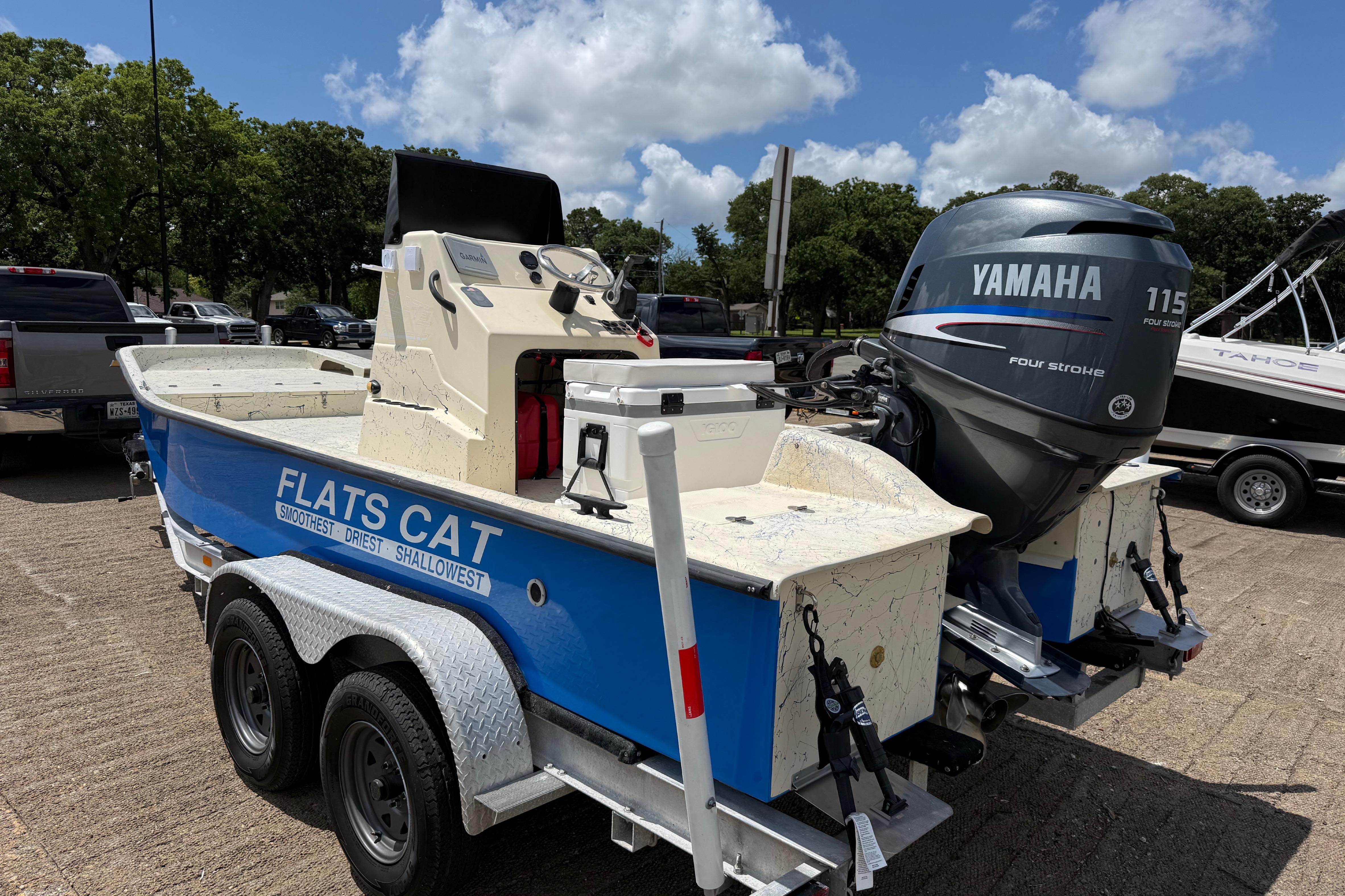 2007 Flats Cat 19 boat with Yamaha 115 engine on trailer, parked outdoors.