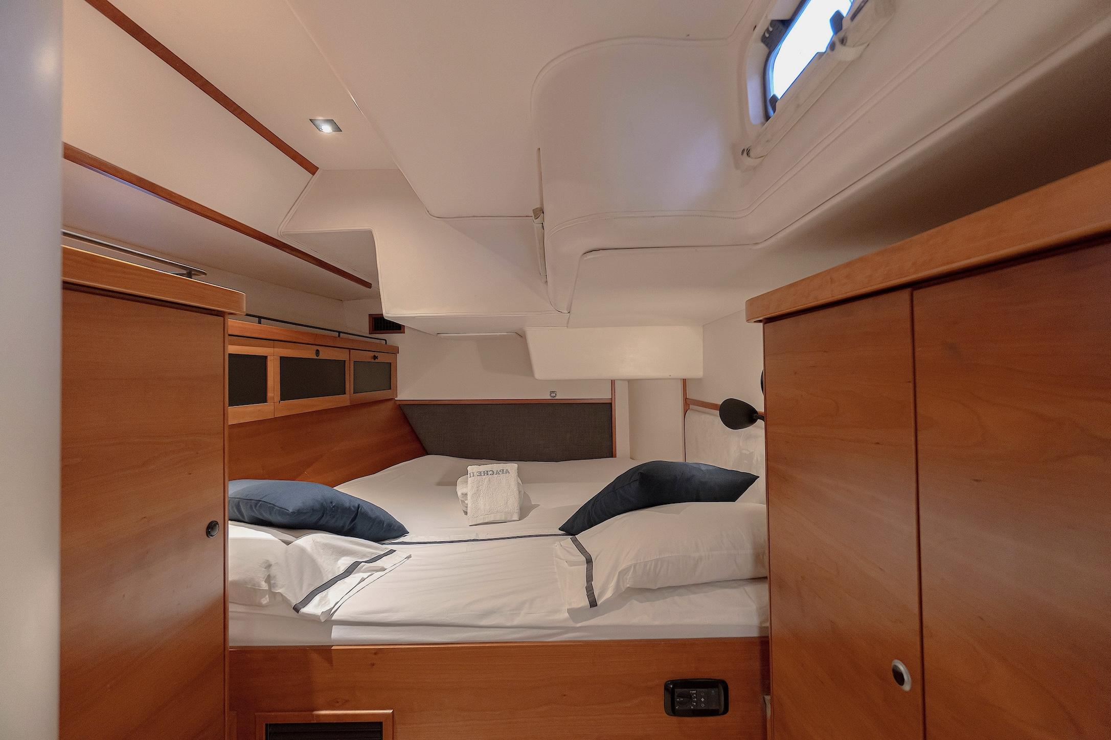 Luxurious cabin interior of 2009 Hanse 630e yacht with cozy bedding and wooden finish.