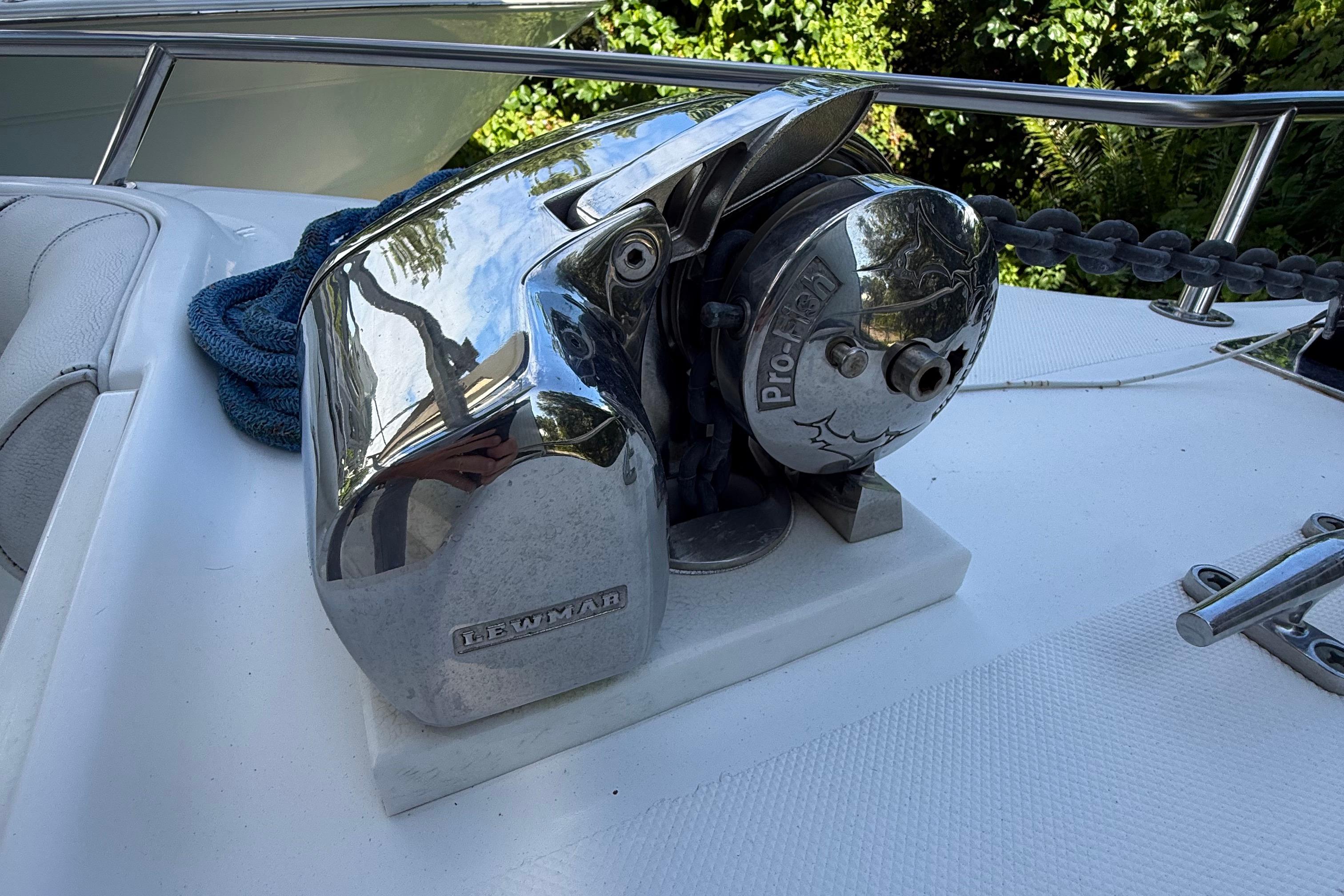 Chrome boat winch on 2008 Century 2901 Center Console, surrounded by greenery.
