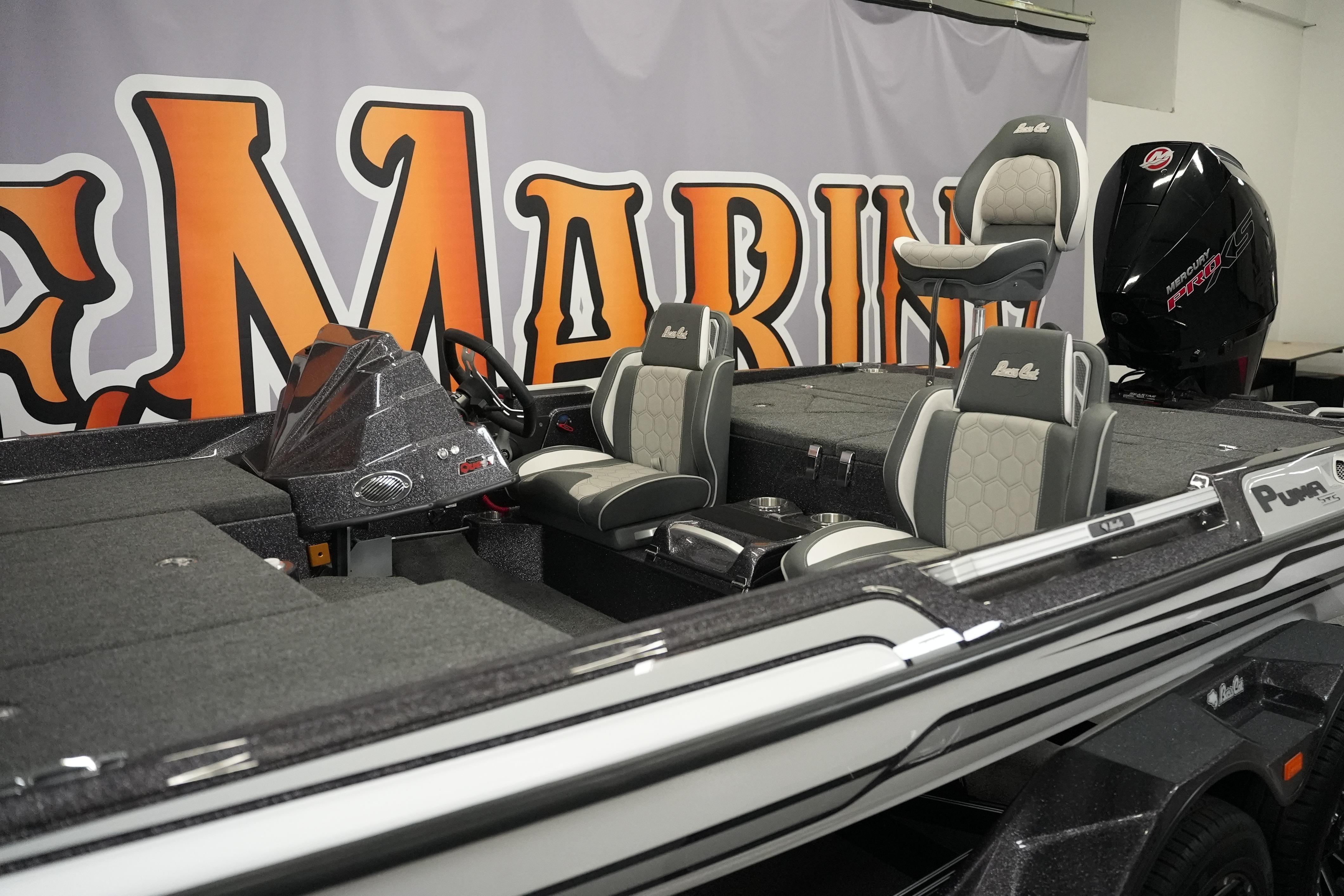 2026 Bass Cat Puma STS boat interior with seating and console, displayed indoors.