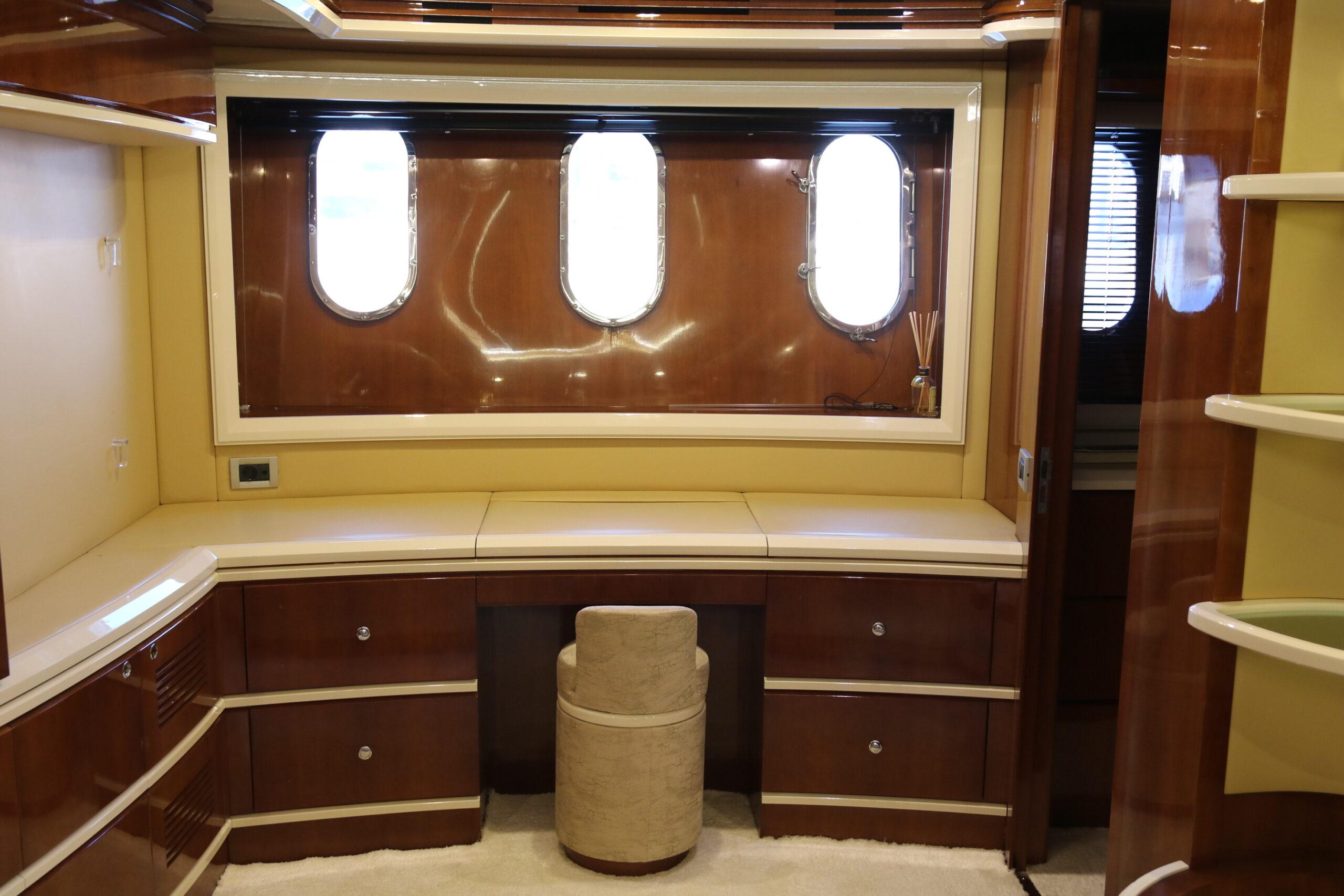 Luxurious interior of 2003 Azimut 98 Leonardo yacht with elegant wood finish and porthole windows.