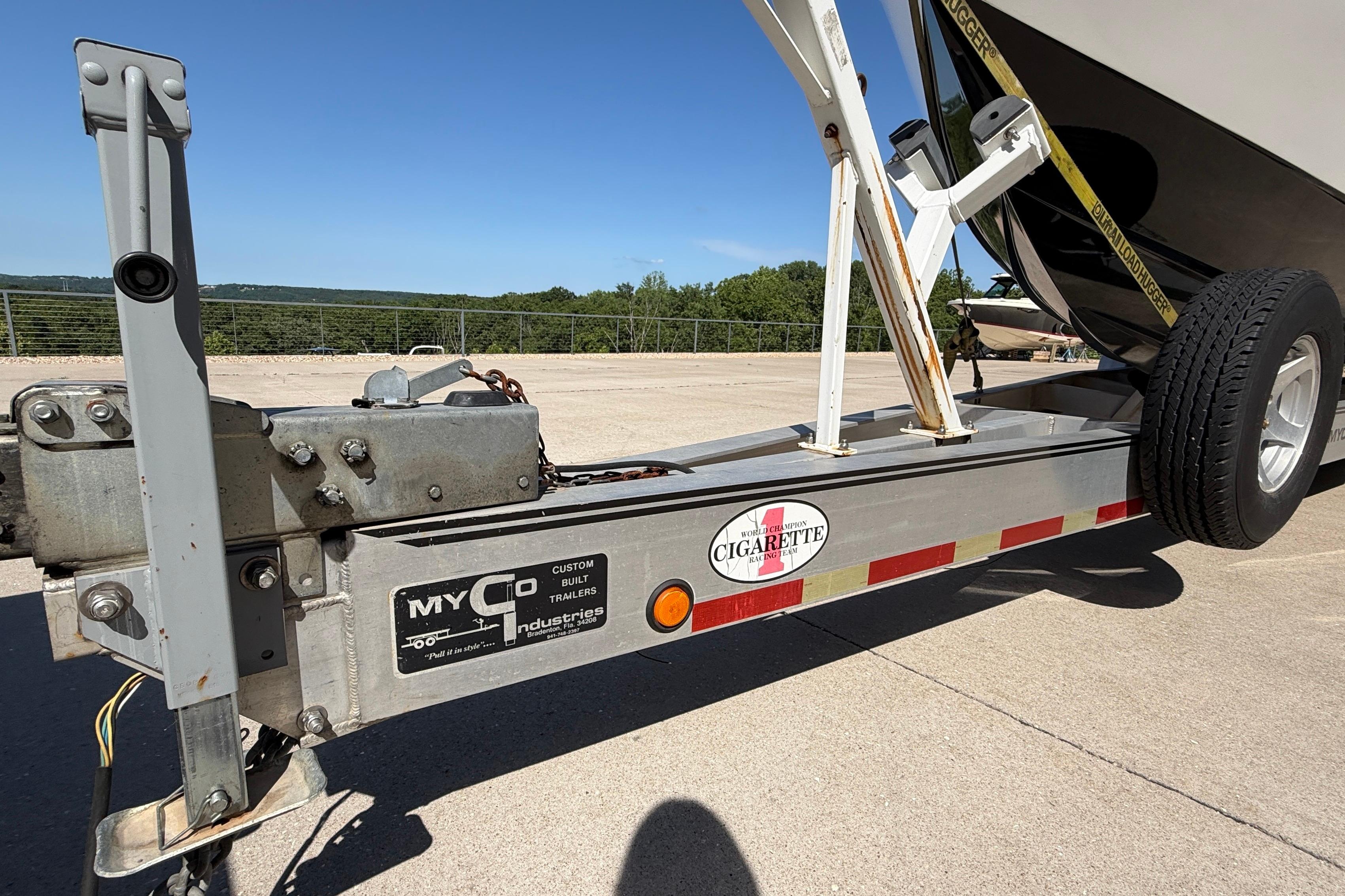 Trailer for 2002 Cigarette 35' Cafe Racer boat, parked outdoors on a sunny day.