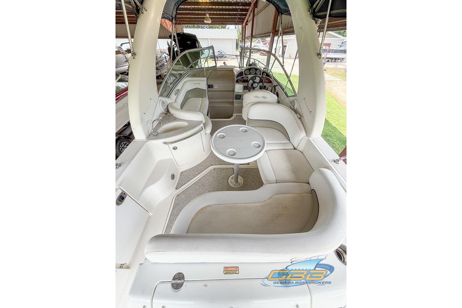 2006 Sea Ray Sundancer 260 interior with spacious seating and helm, under covered dock.