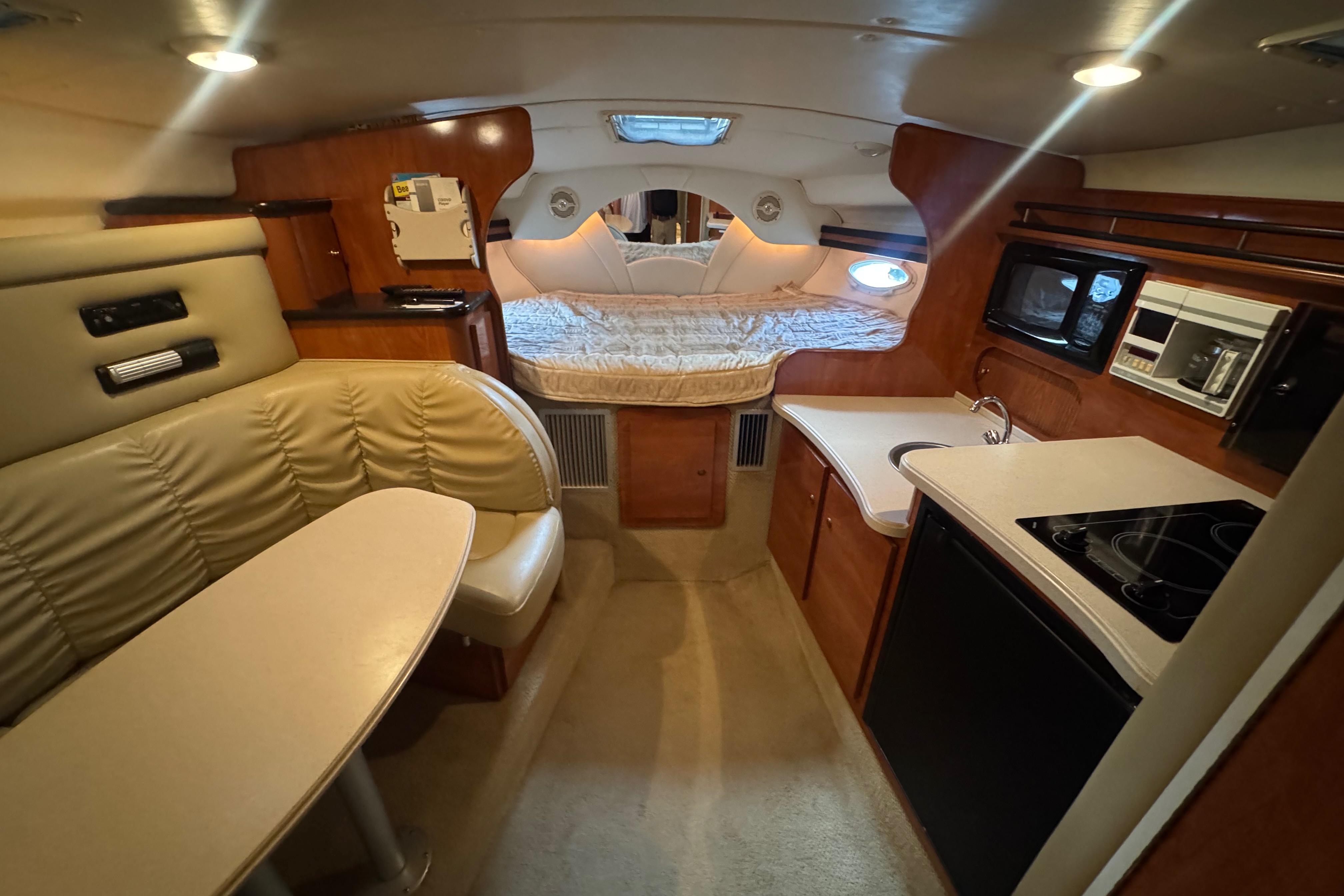 2004 Rinker Fiesta Vee 312 cabin interior with kitchenette, seating, and sleeping area.