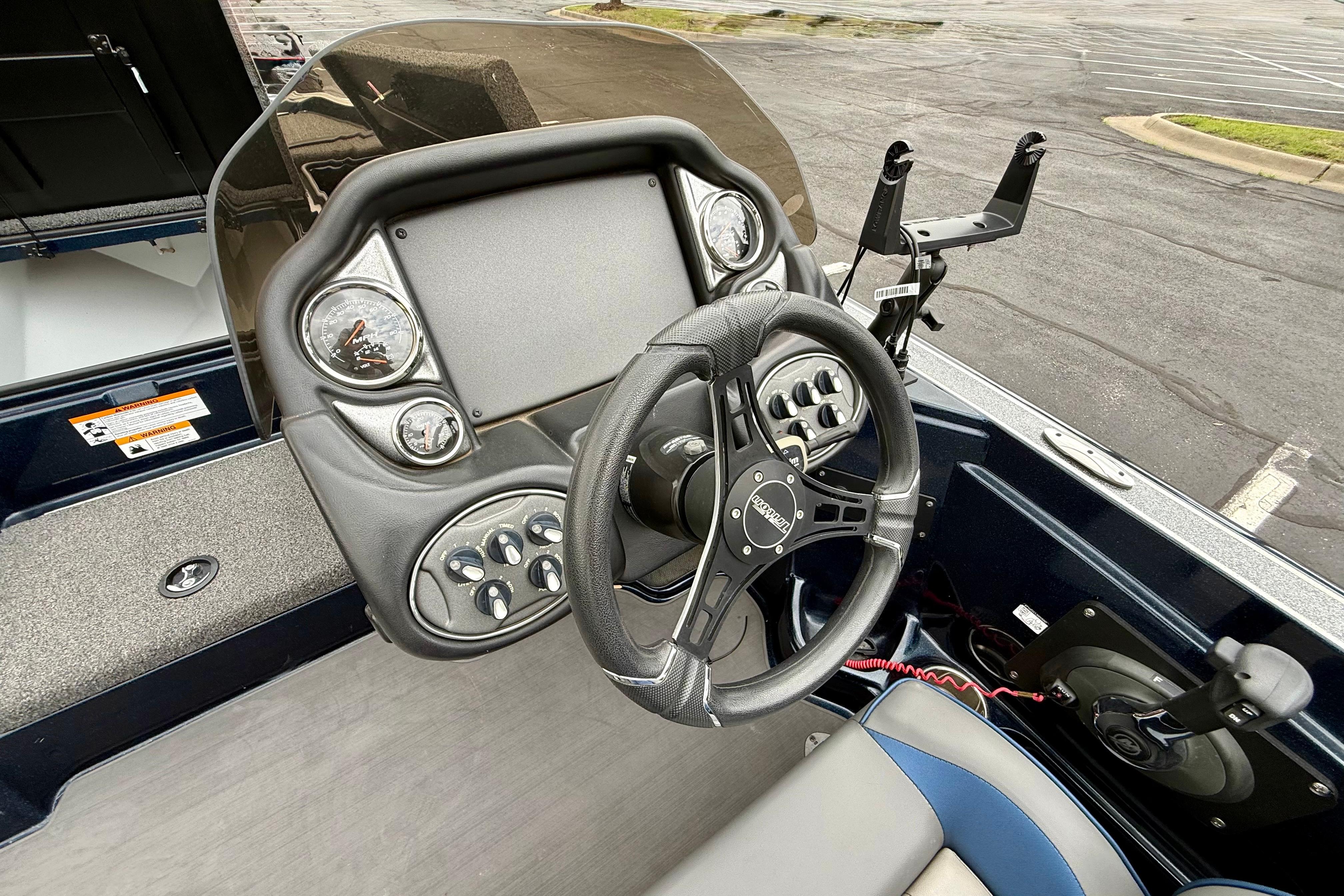 2023 Triton 18 TrX boat dashboard with steering wheel and control panel.