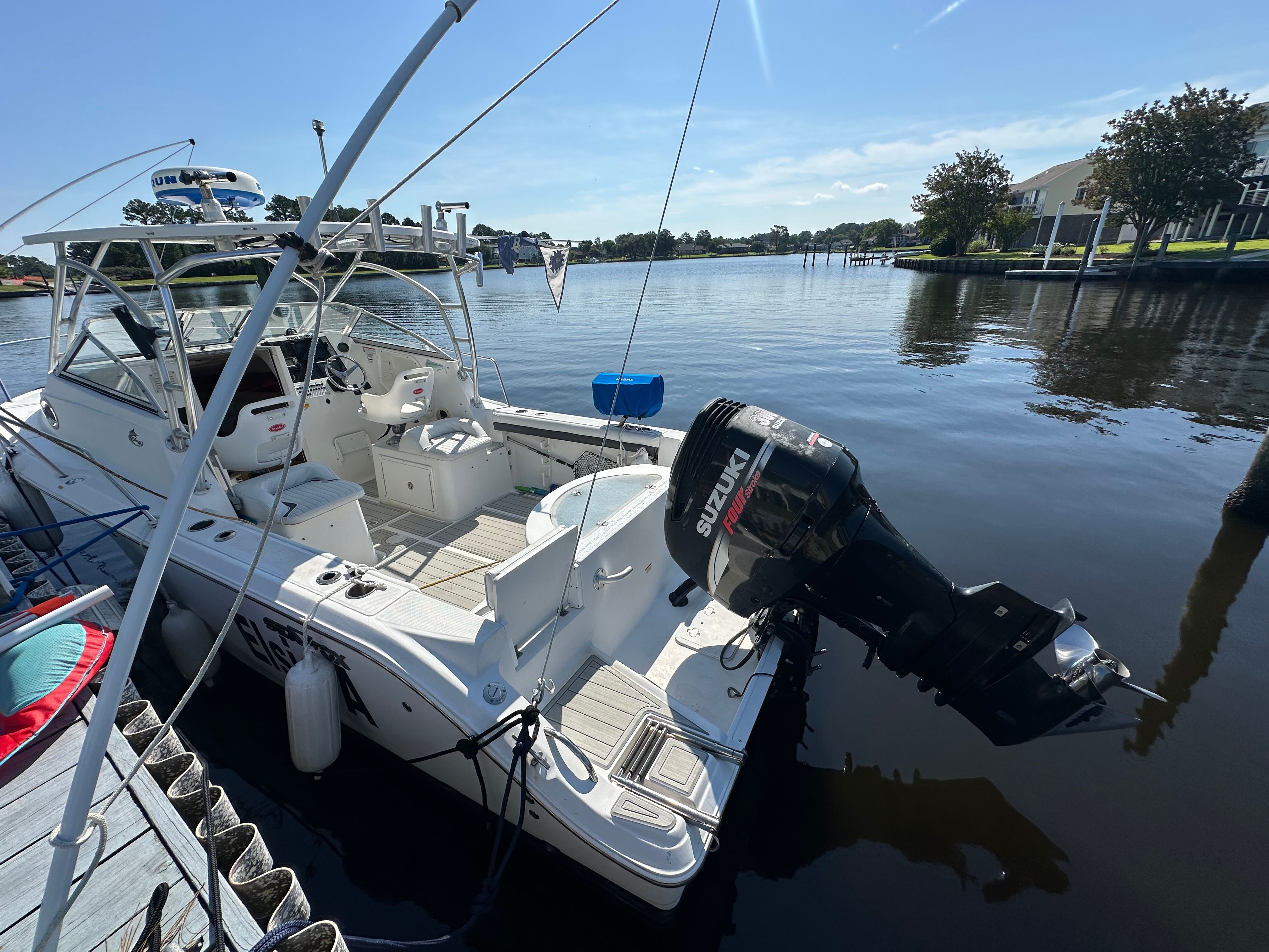 A 2009 Sea Fox 256WA docked in calm waters, featuring a Suzuki outboard motor.