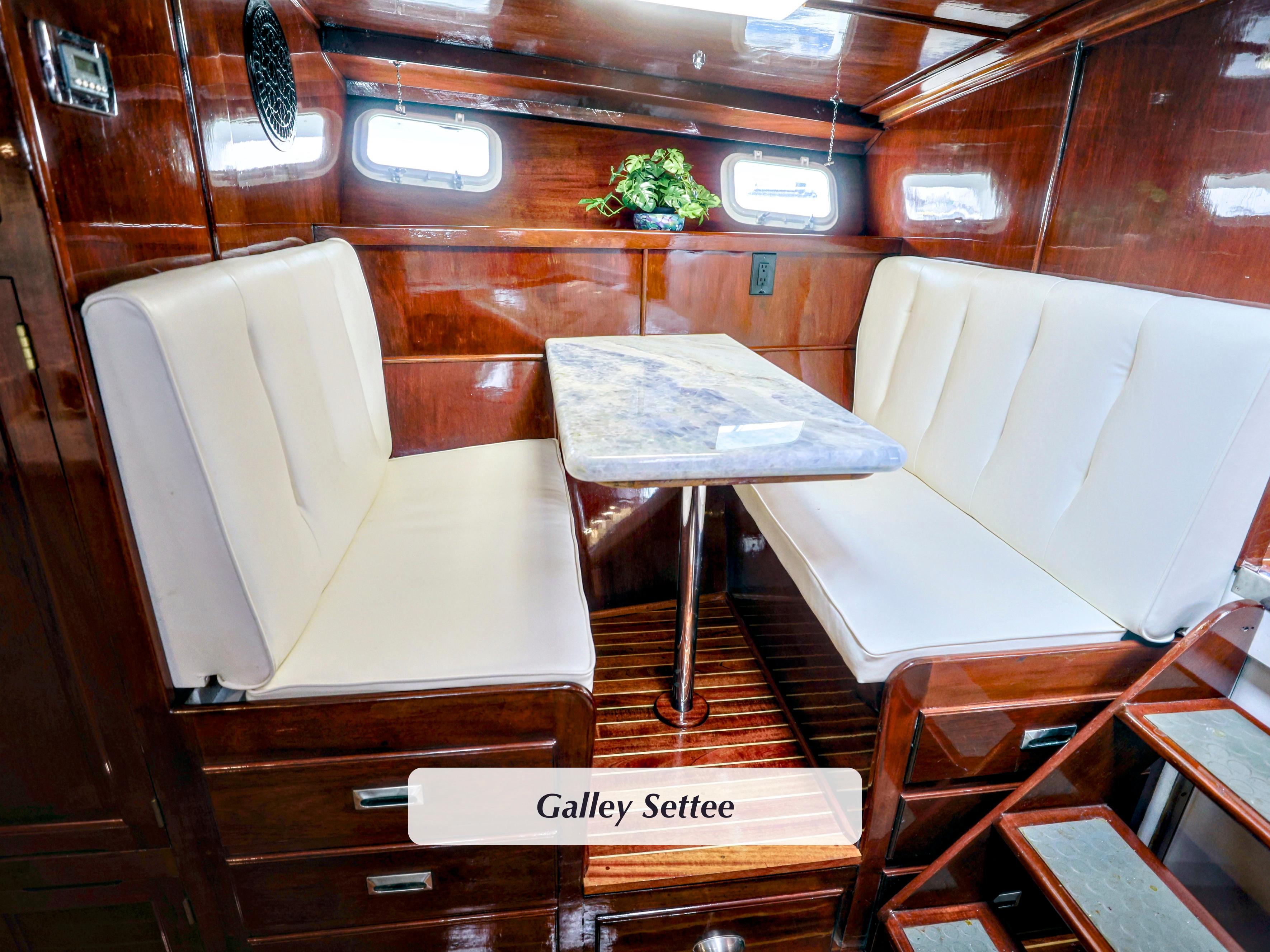 1968 Stephens Motor Yacht galley settee with white cushions and wooden interior.