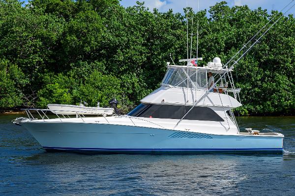 2000 Viking 50 Convertible yacht cruising on a serene waterway.