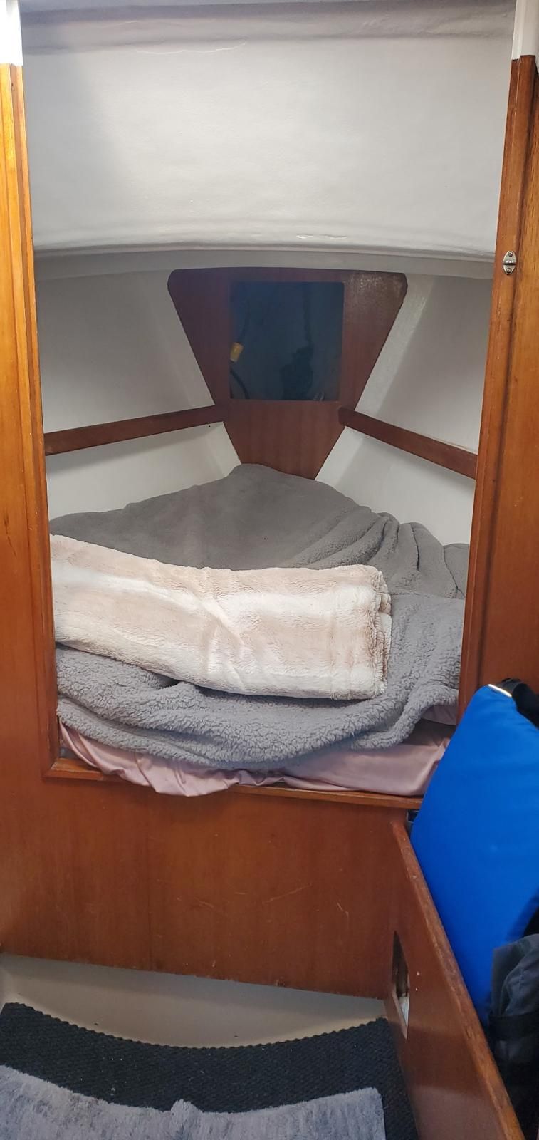 Interior of a cabin with a cozy bed and blankets.
