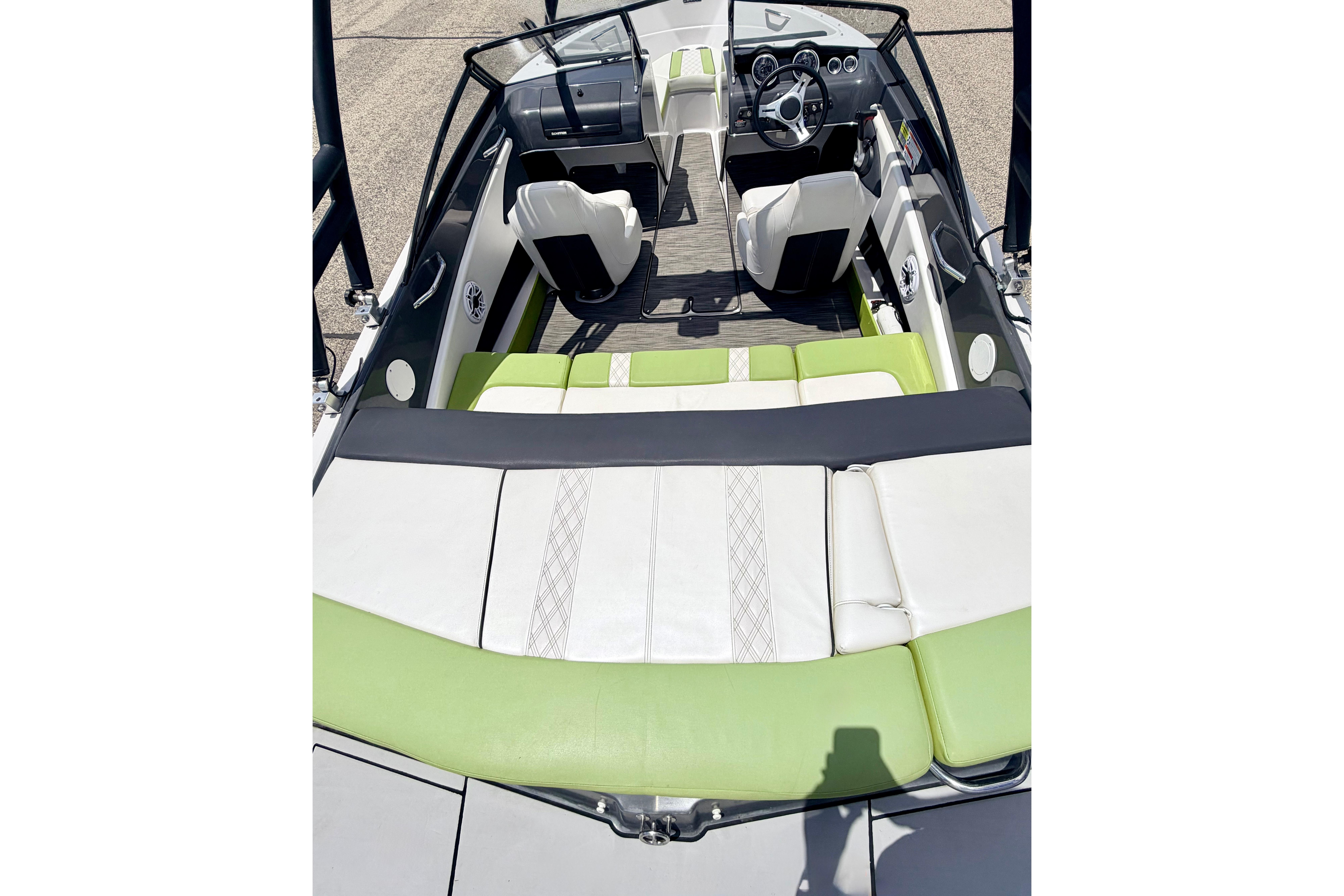 2018 Glastron GT 185 boat interior with green and white seating, steering wheel, and dashboard.