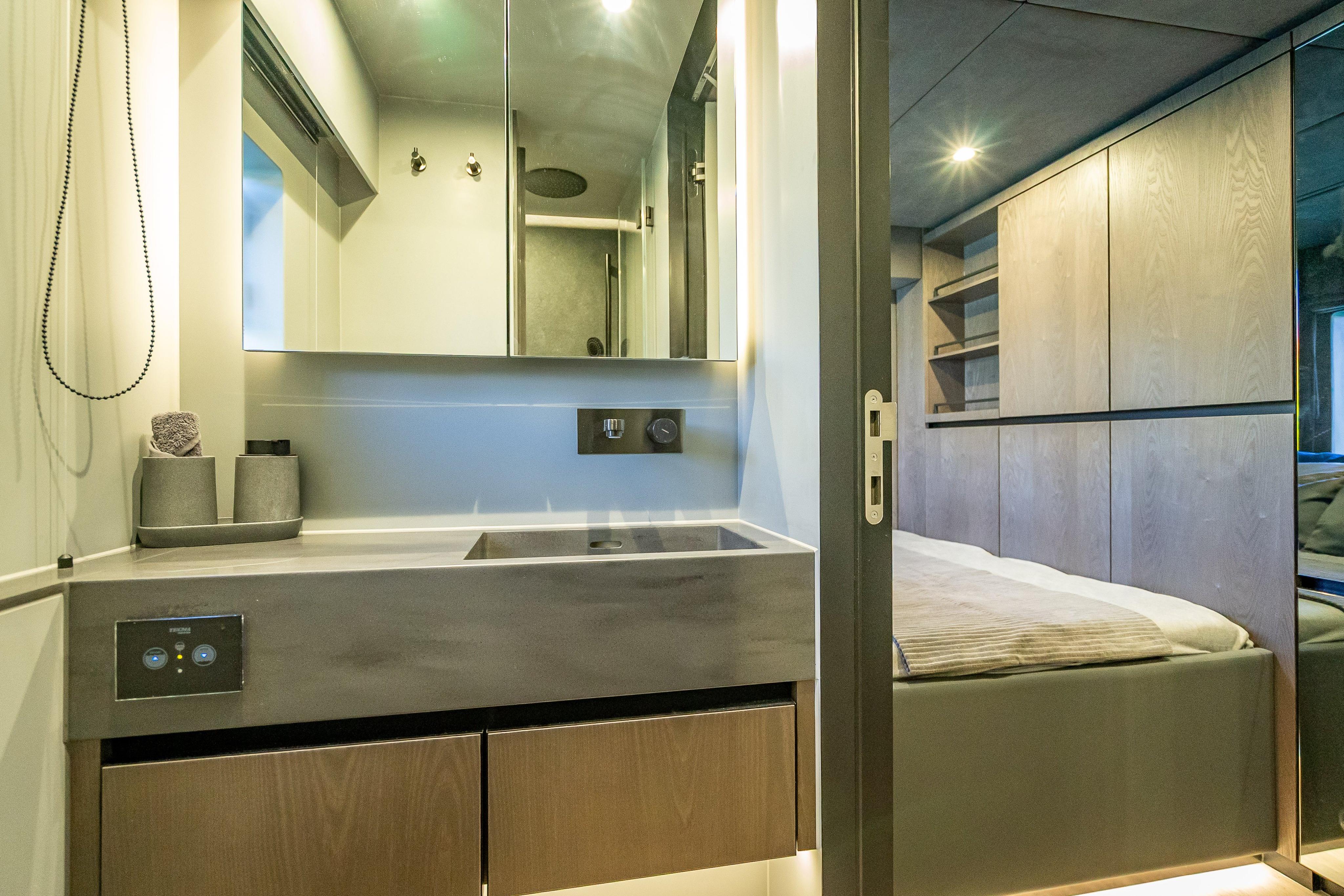 Luxurious interior of 2026 Sunreef 60 Power yacht featuring modern bathroom and bedroom.
